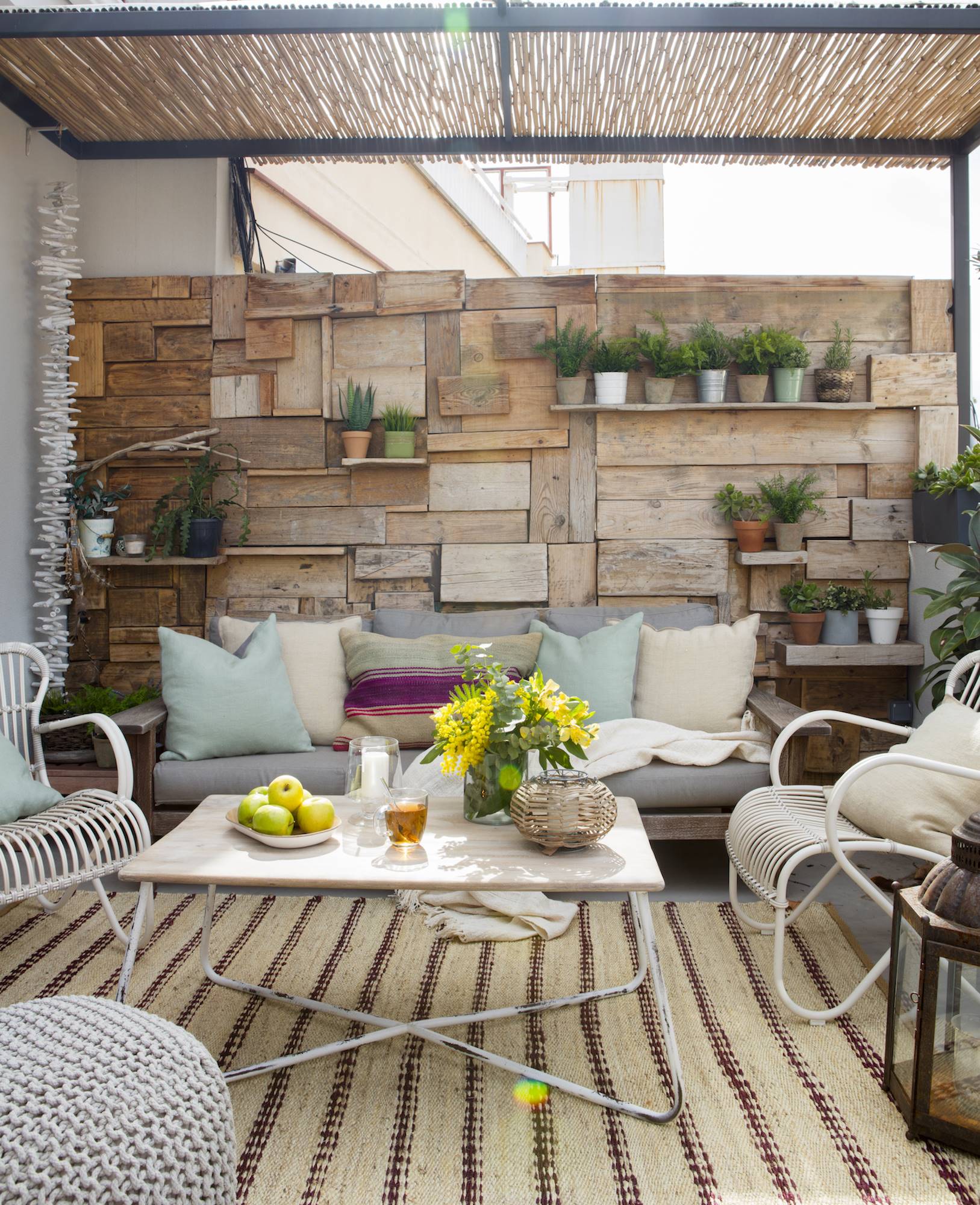 Terraza con sofás y pared de madera.