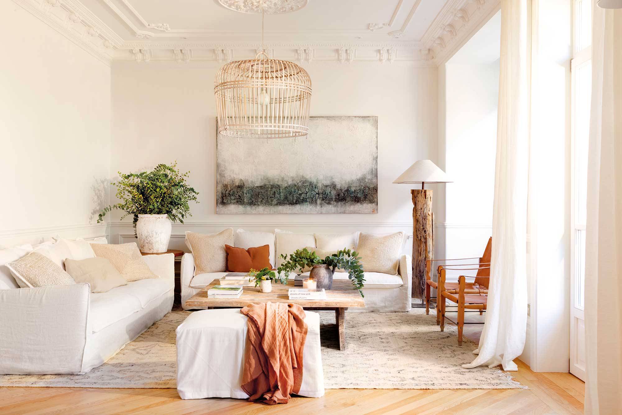 Salón señorial decorado en blanco y madera con sofás de lino y un cuadro en la pared 00532058