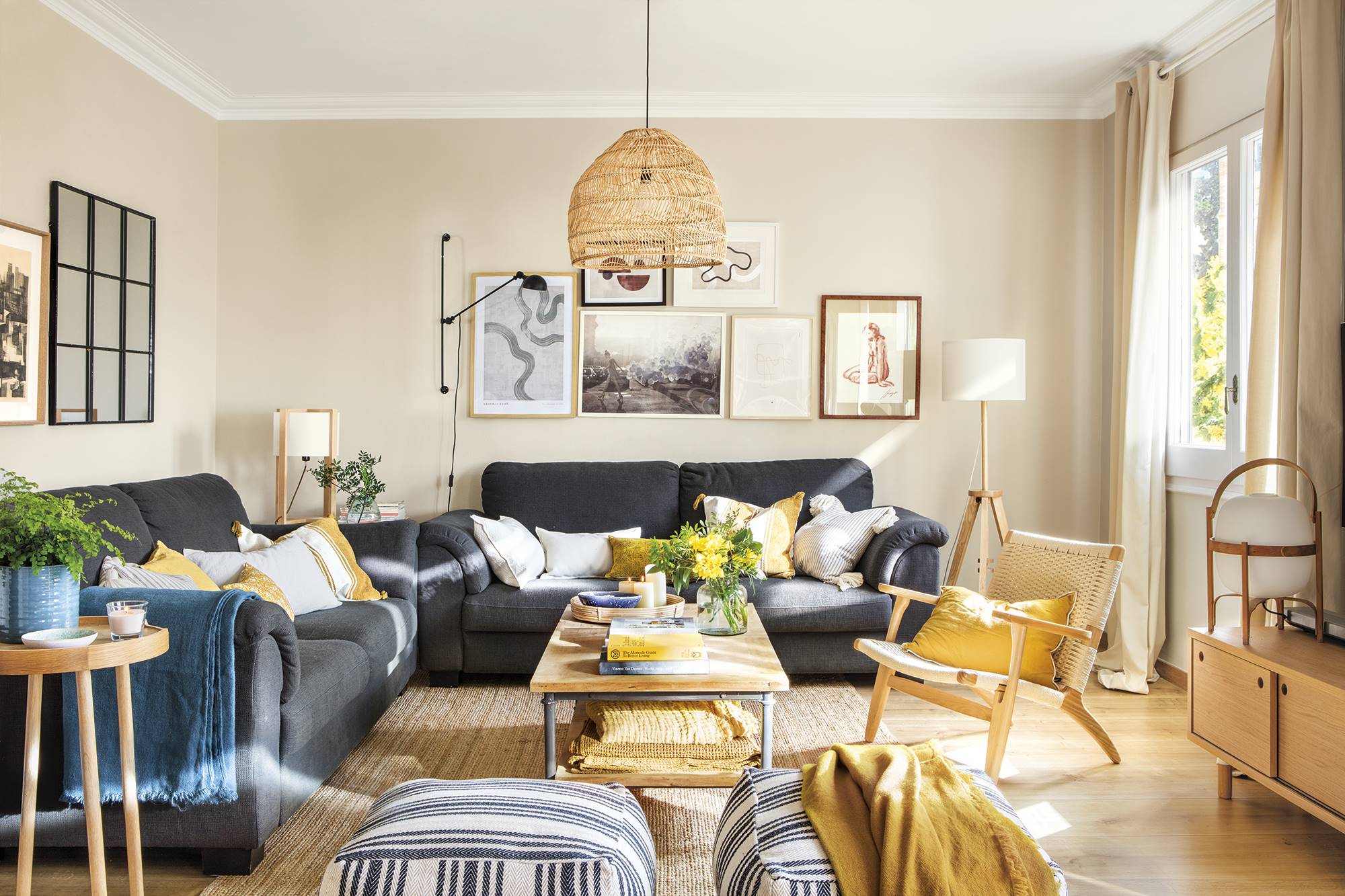 Salón con paredes beige, sofás grises y detalles en fibras naturales. 