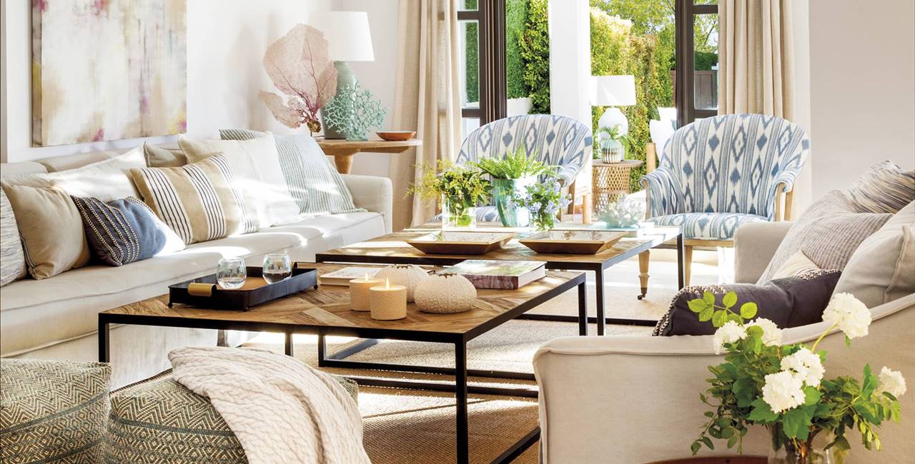 Salón con sofás de lino beige, pufs étnicos, alfombra de fibras y mesas de centro 00526262