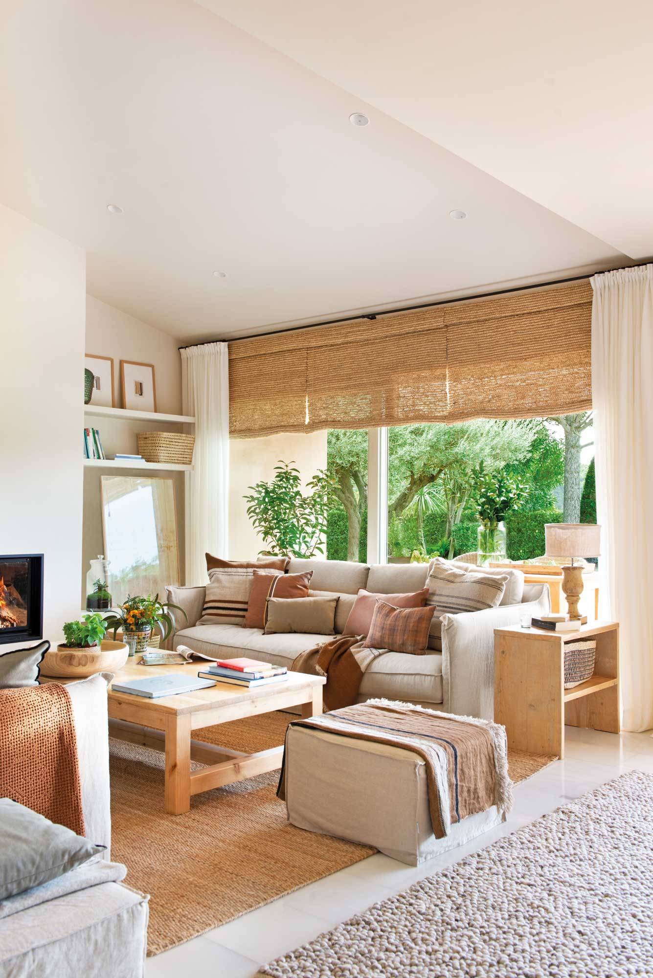 Salón con ventanal decorado en tonos neutros con muebles de madera y piezas de fibras naturales 00531366