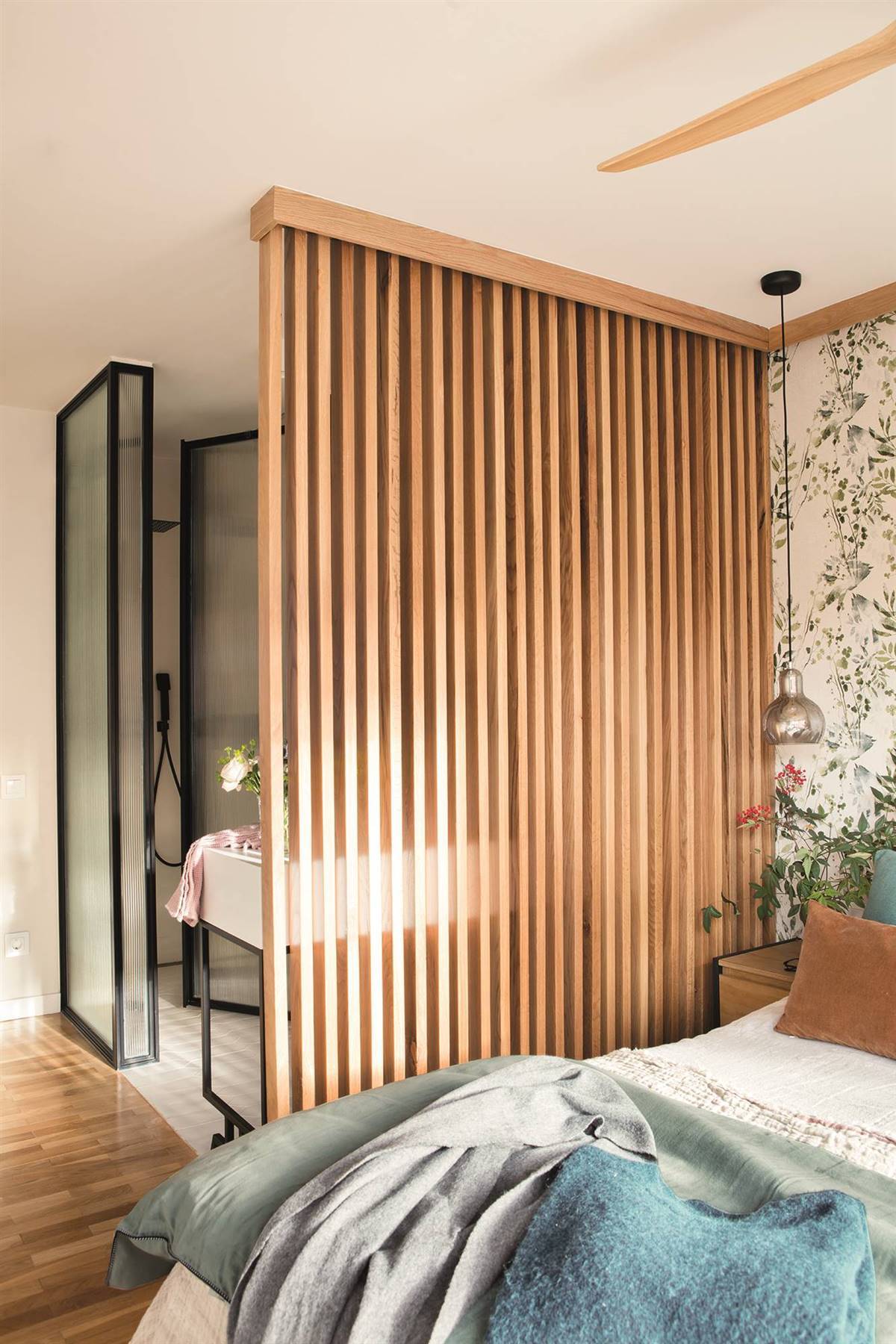 Dormitorio con celosía de madera que separa del baño