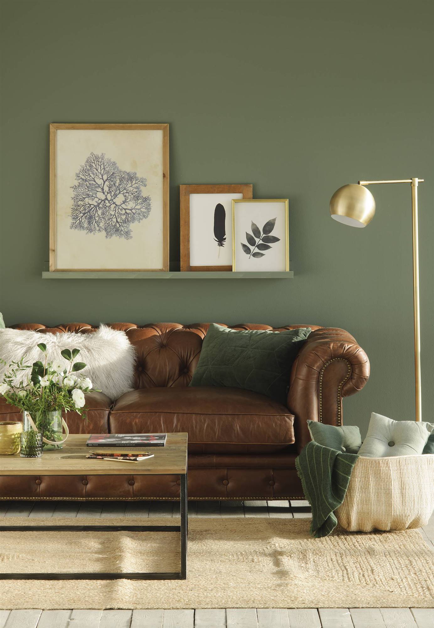 Salón con paredes verdes y sofá chéster. 