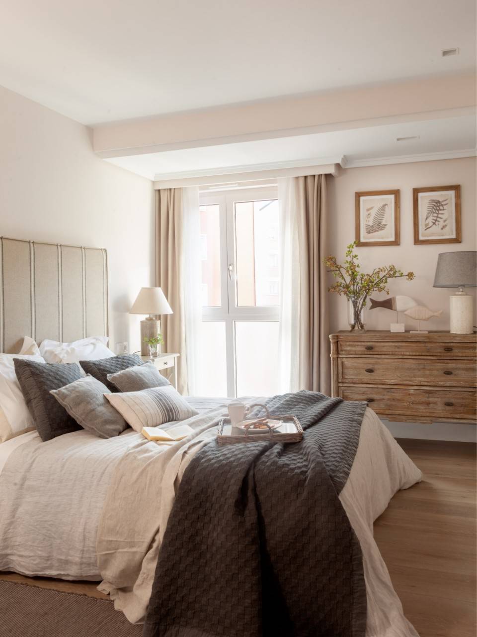 Dormitorio con cabecero tapizado con tejido de rayas. 