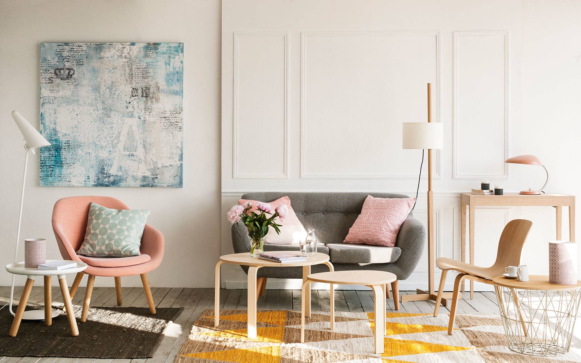 Salón de estilo nórdico con sofá gris y butaca rosa