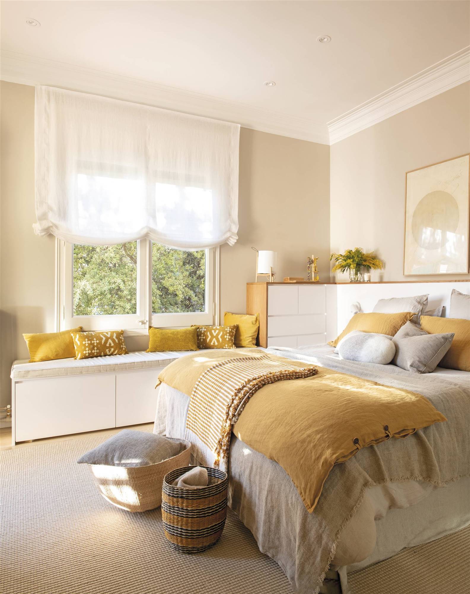 Dormitorio con muebles en blanco y roble y ropa de cama amarilla. 