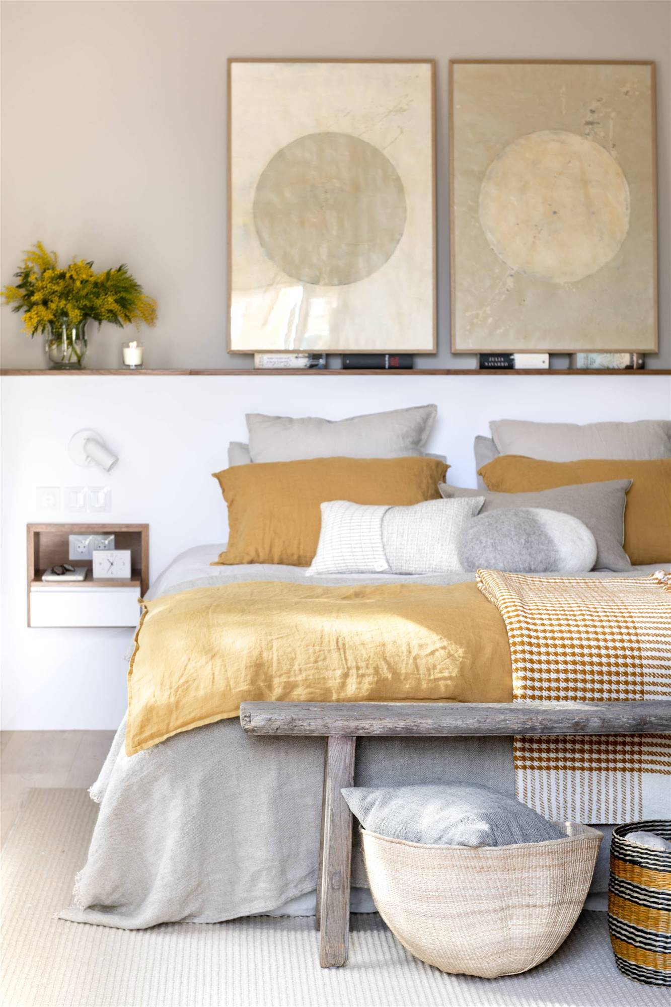 Dormitorio con cabecero de obra y ropa de cama de color mostaza. 