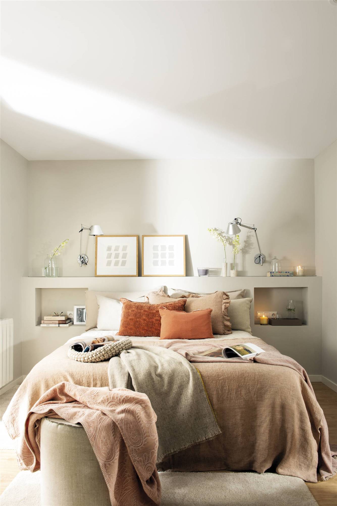 Dormitorio decorado en tonos rosas con cabecero de obra y un puf a los pies de la cama 513213