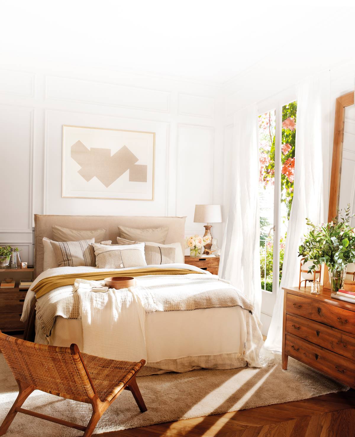Dormitorio de estilo natural con butaca trenzada a pie de cama 00501570