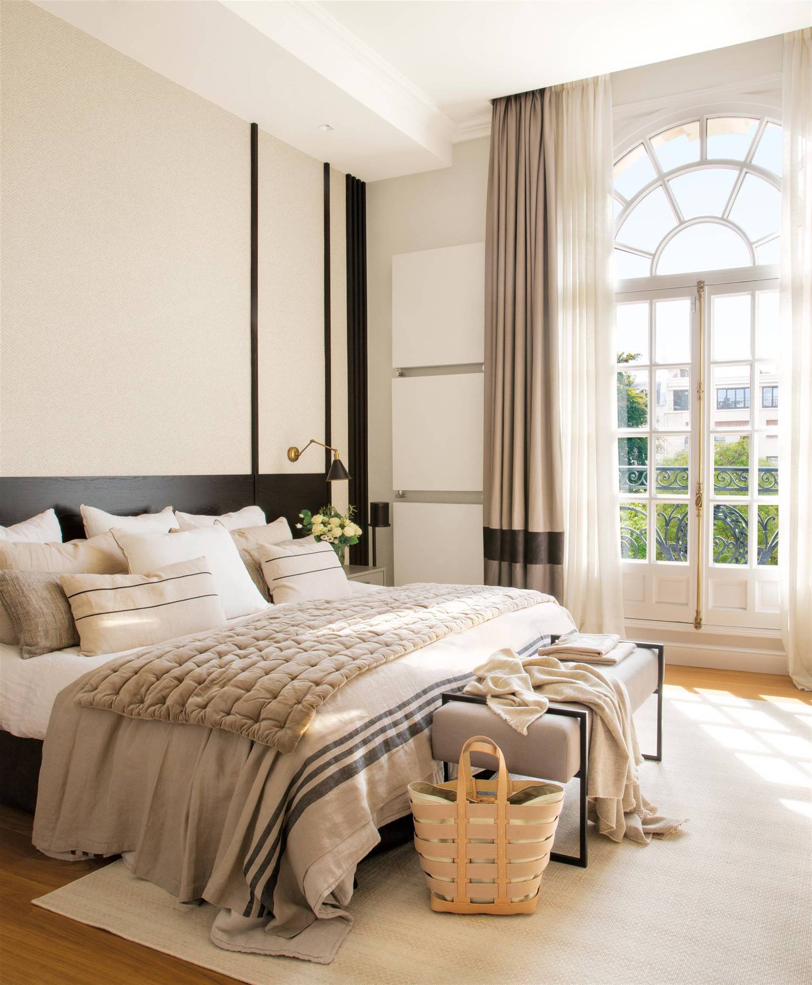 Dormitorio con techos altos decorado en blanco, beige y negro.