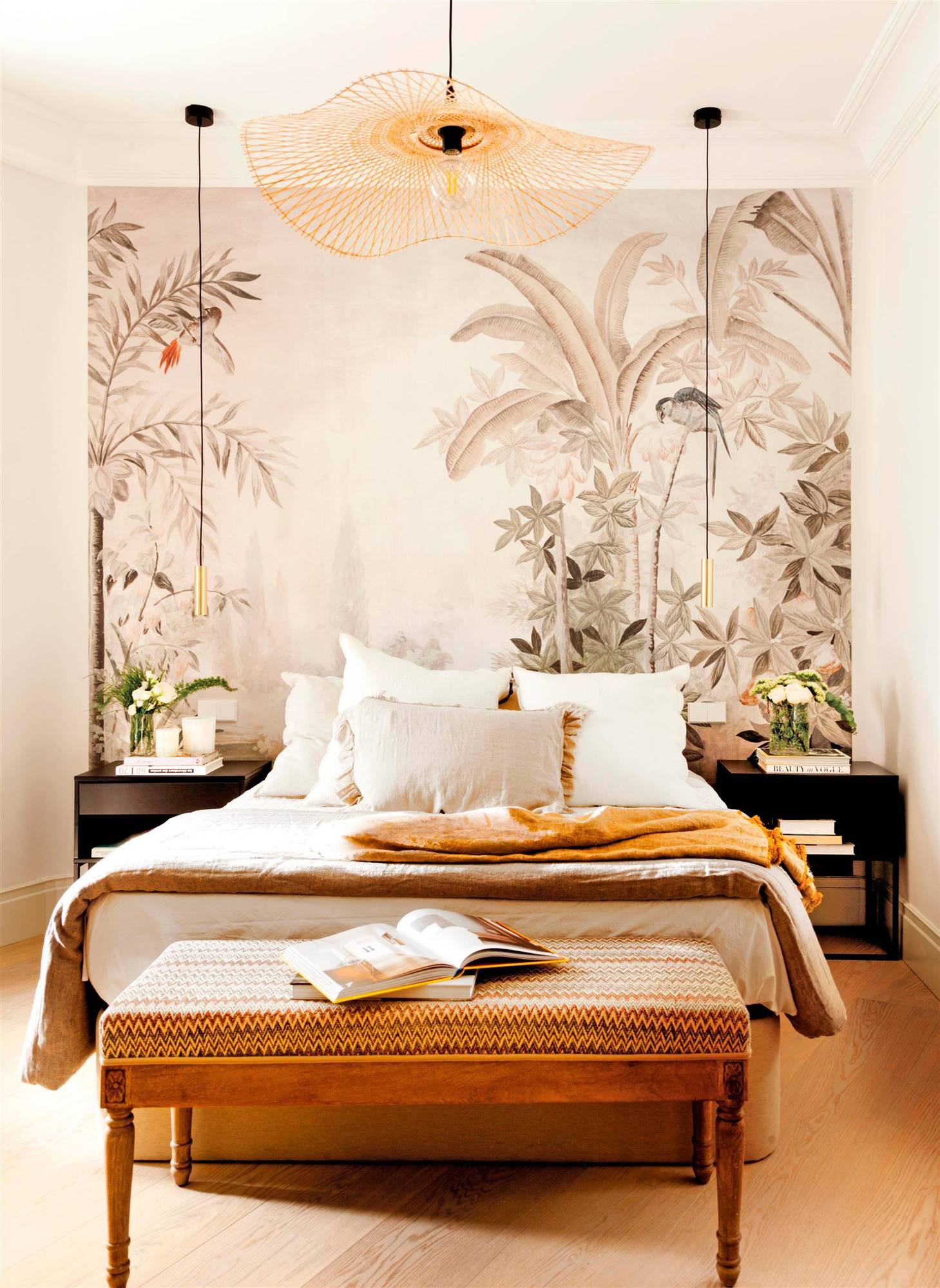 Dormitorio moderno con pared de cabecero revestido de un mural exótico, mesillas negras y lámparas suspendidas.