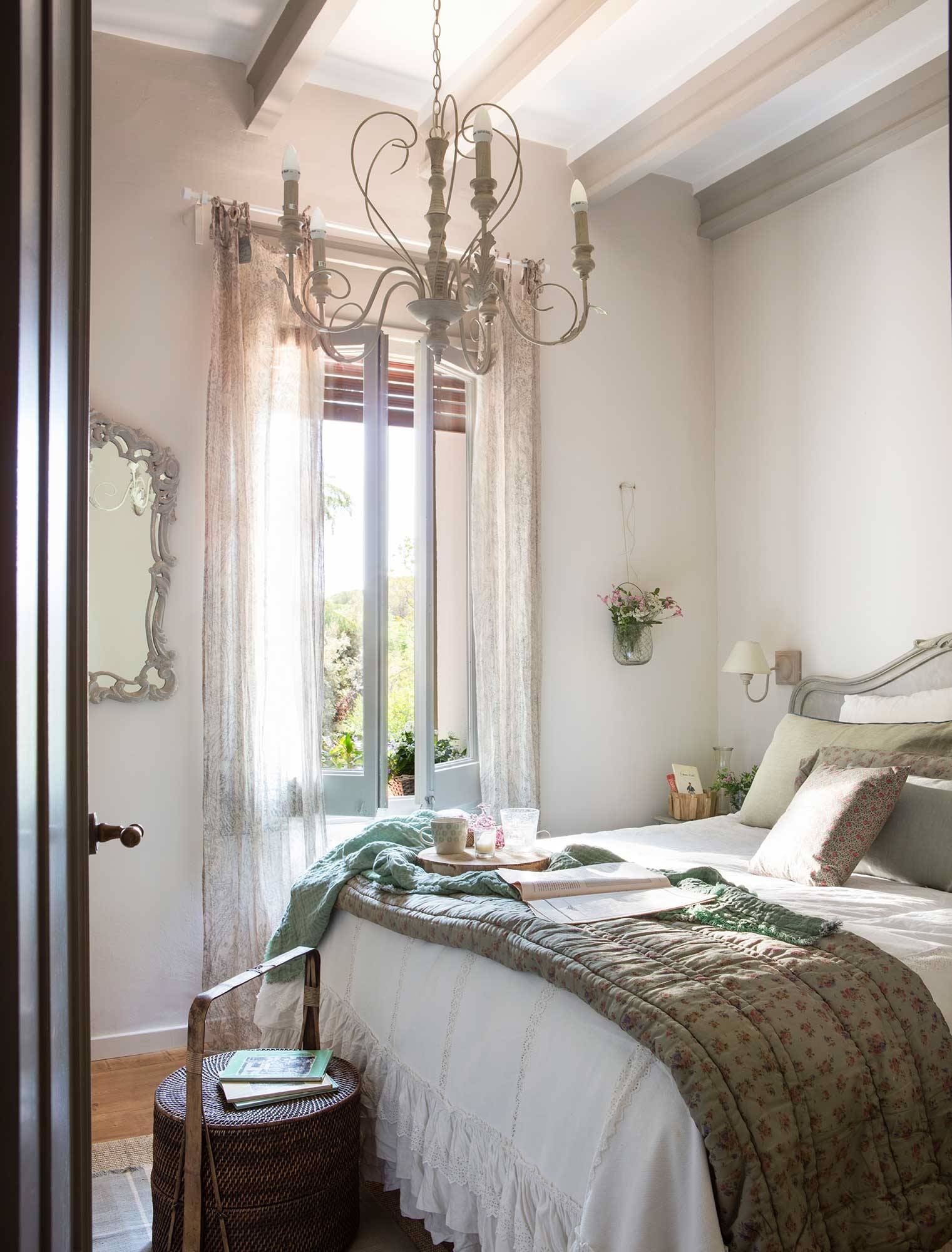 Dormitorio clásico con lámpara de araña. 