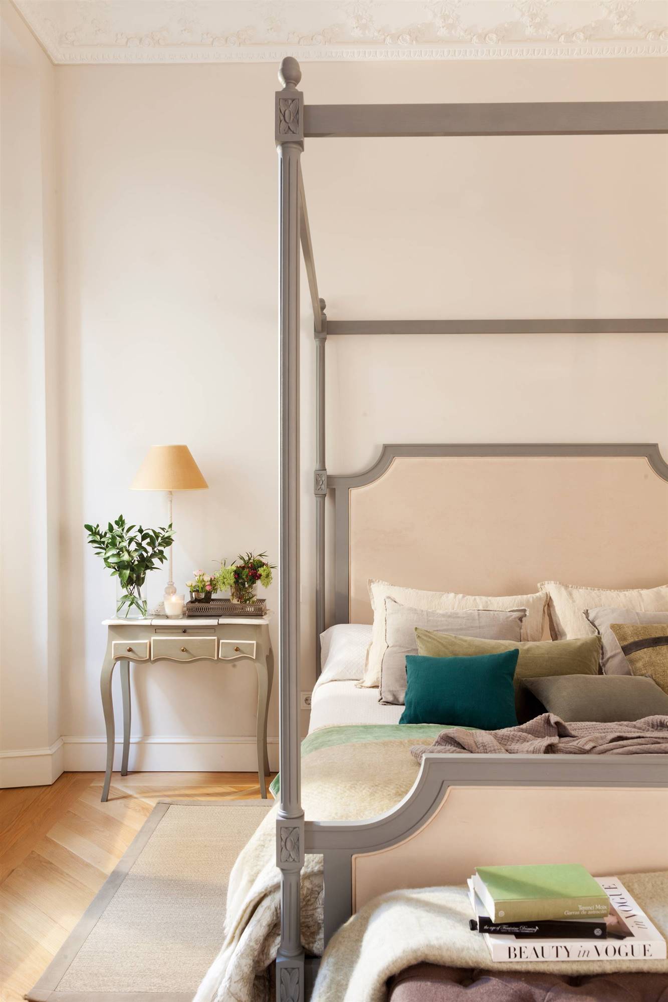 Dormitorio clásico con cama con dosel y cabecero tapizado