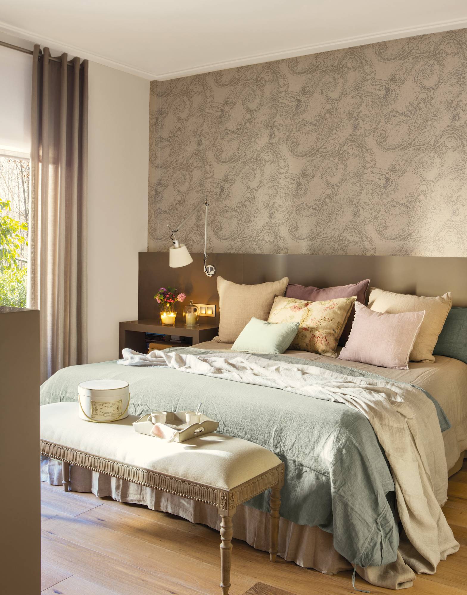 Dormitorio con cabecero y mesillas en color topo y papel pintado con estampado Paisley