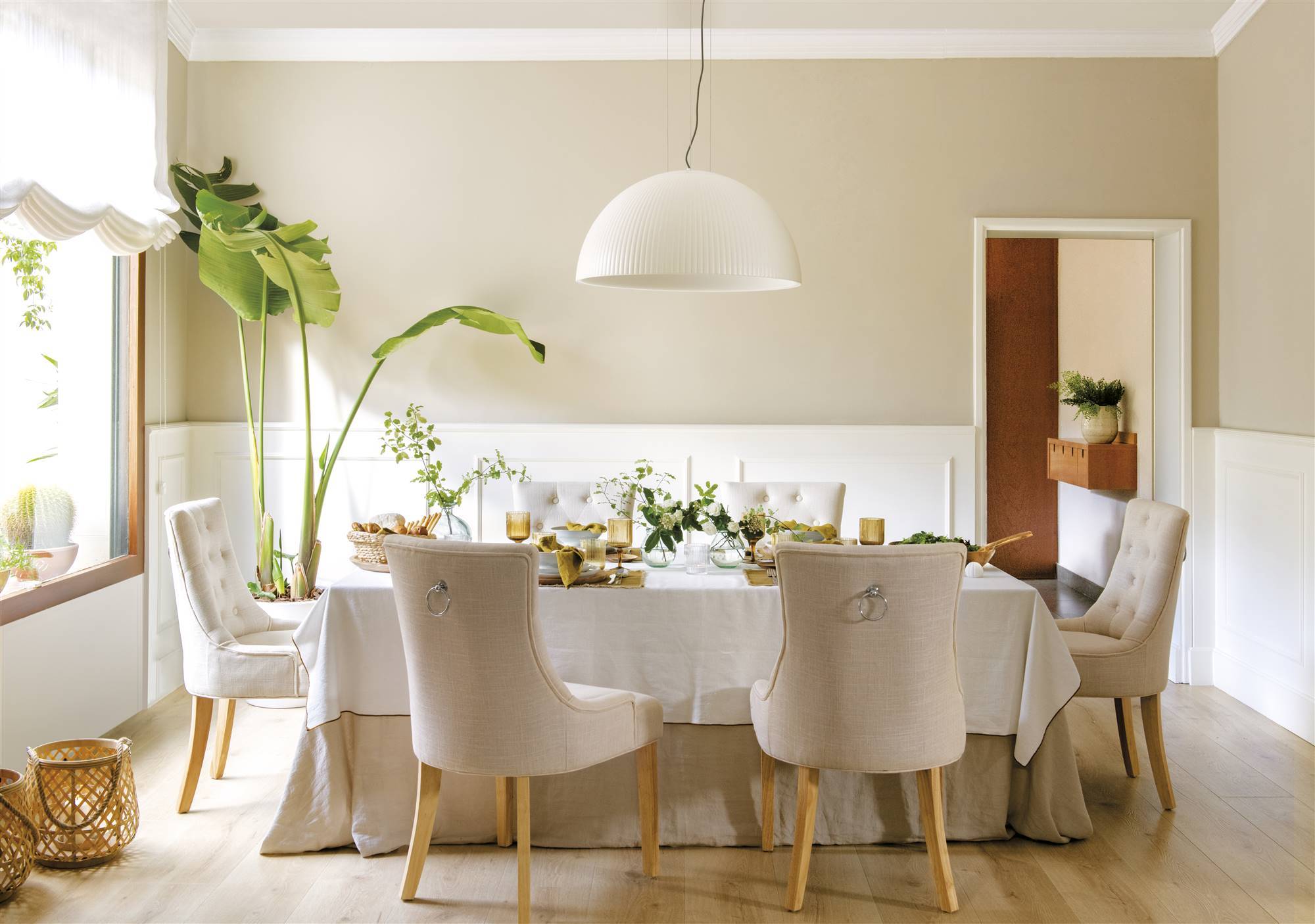 Comedor con sillas en color blanco y una mesa grande. 