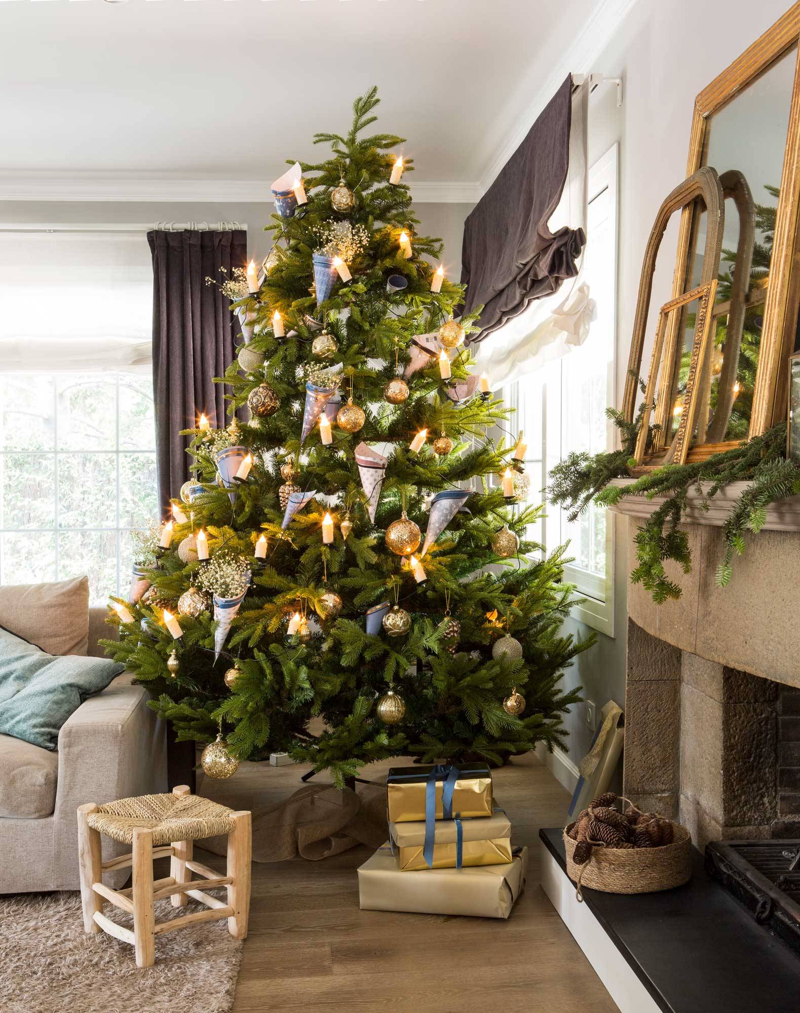 Salón con árbol de Navidad decorado con adornos azules y dorados. 