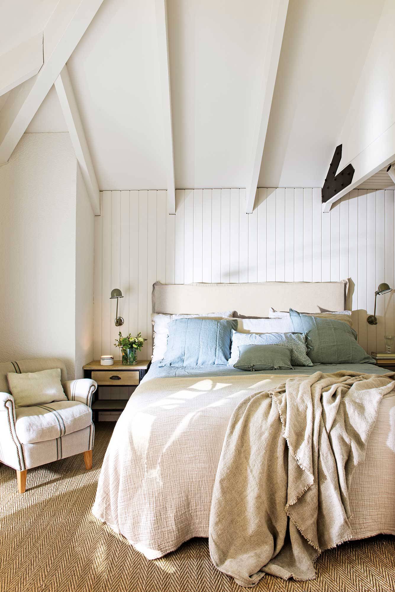 Dormitorio abuhardillado blanco con suelo de moqueta.