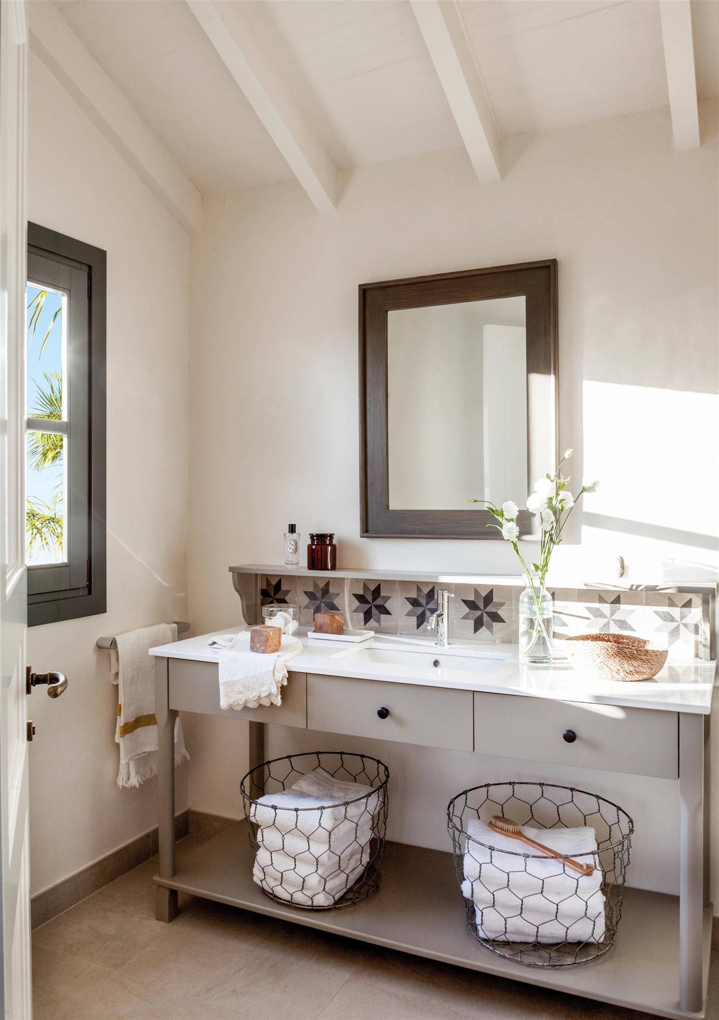 Baño clásico con mueble de lavabo en gris claro con espejo y azulejos hidráulicos. 