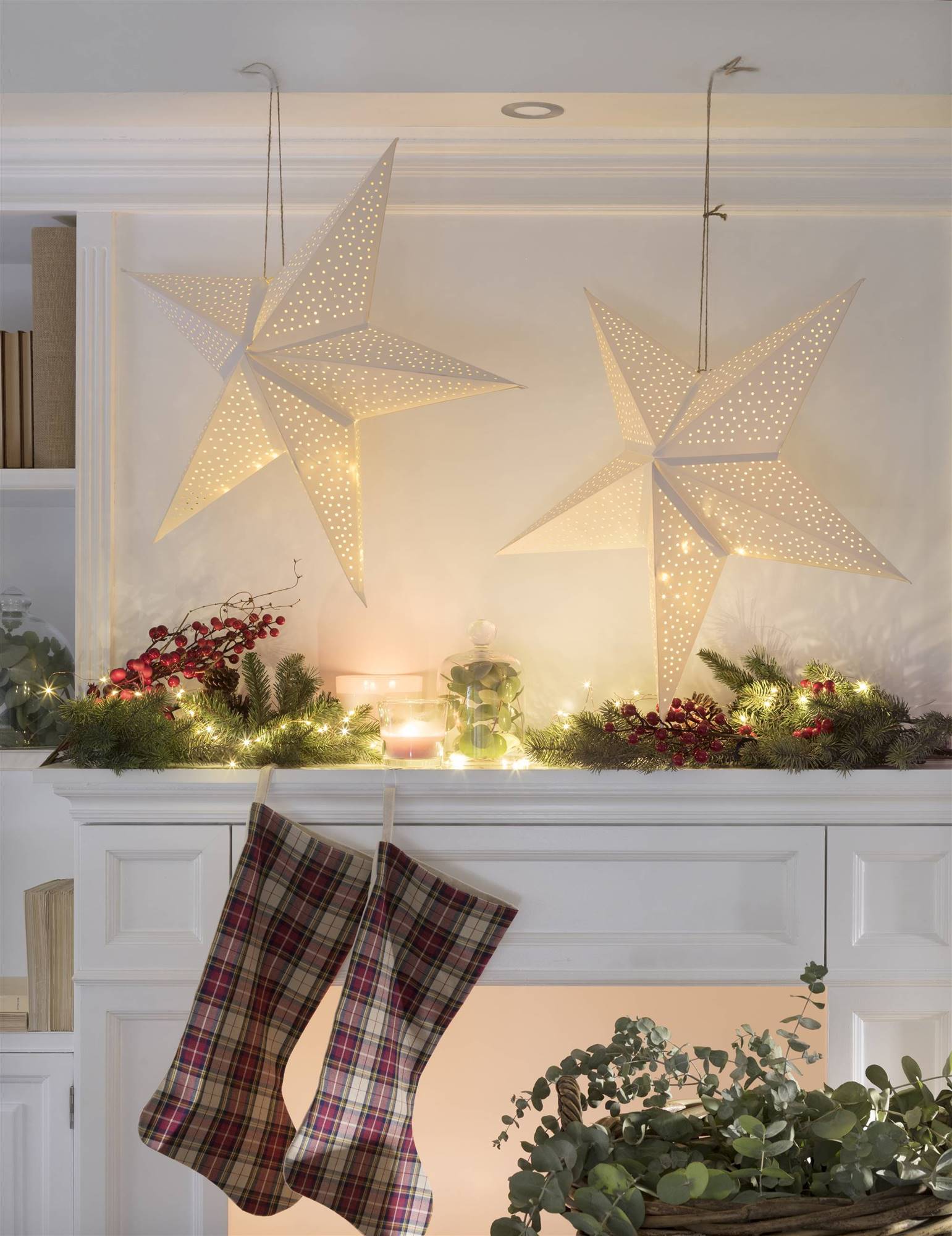 Chimenea decorada de Navidad con estrellas, guirnaldas y calcetines. 