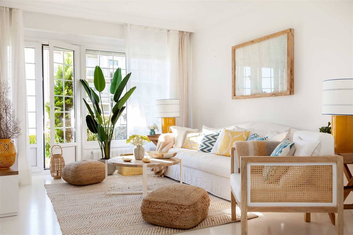 Salón blanco con gran sofá y butaca fibras