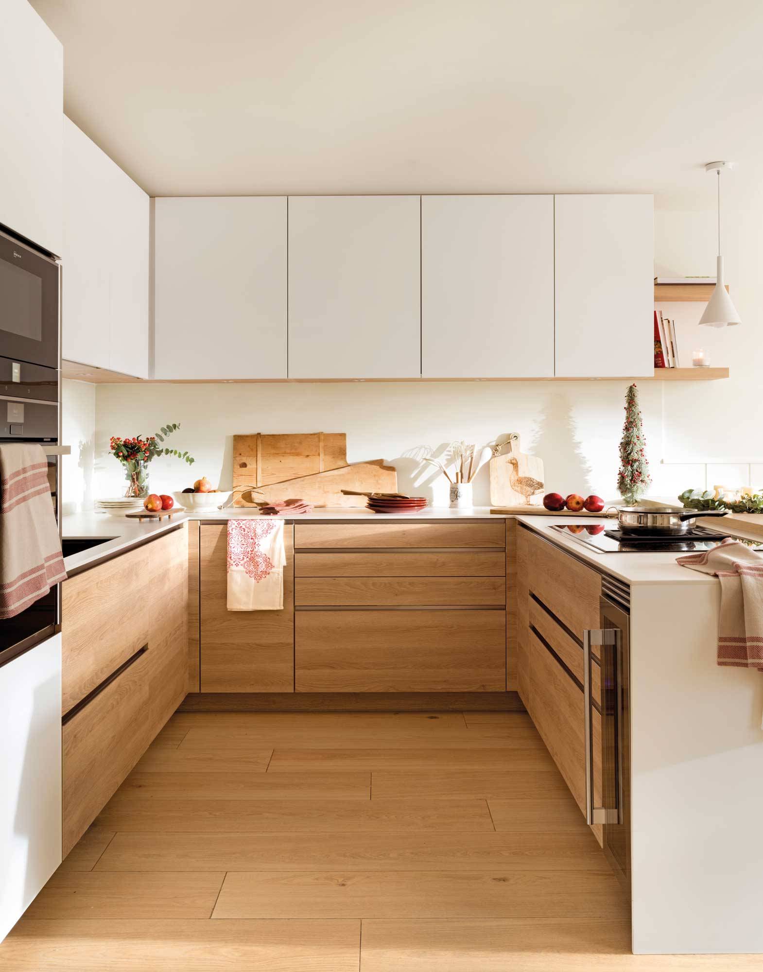 Cocina blanca con muebles de madera y electrodomésticos, de Schmidt. 