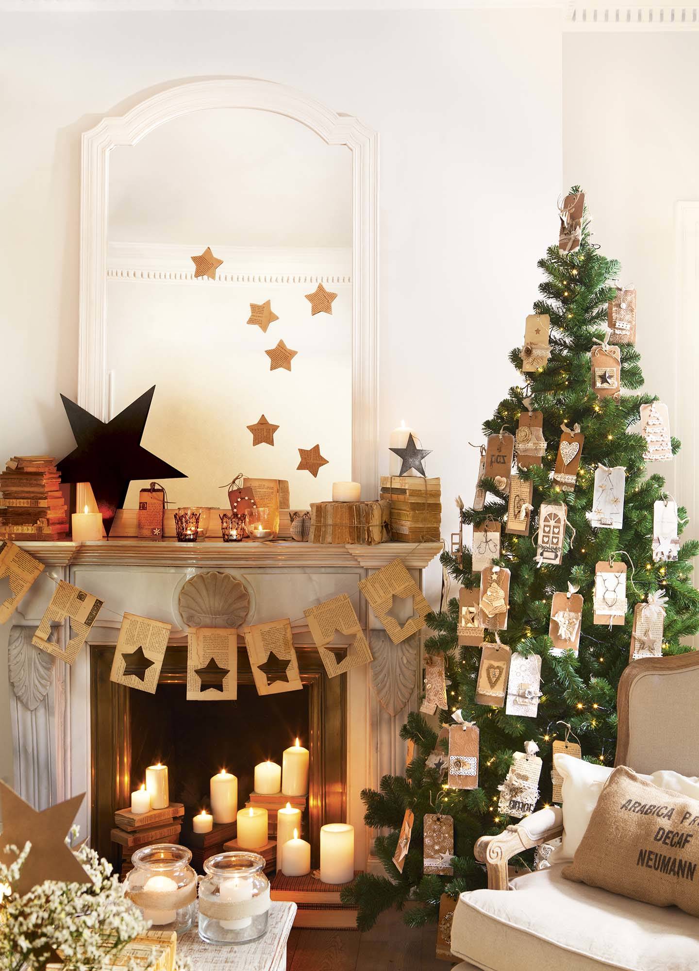 Árbol de Navidad decorado con tarjetas DIY y chimenea con velas.