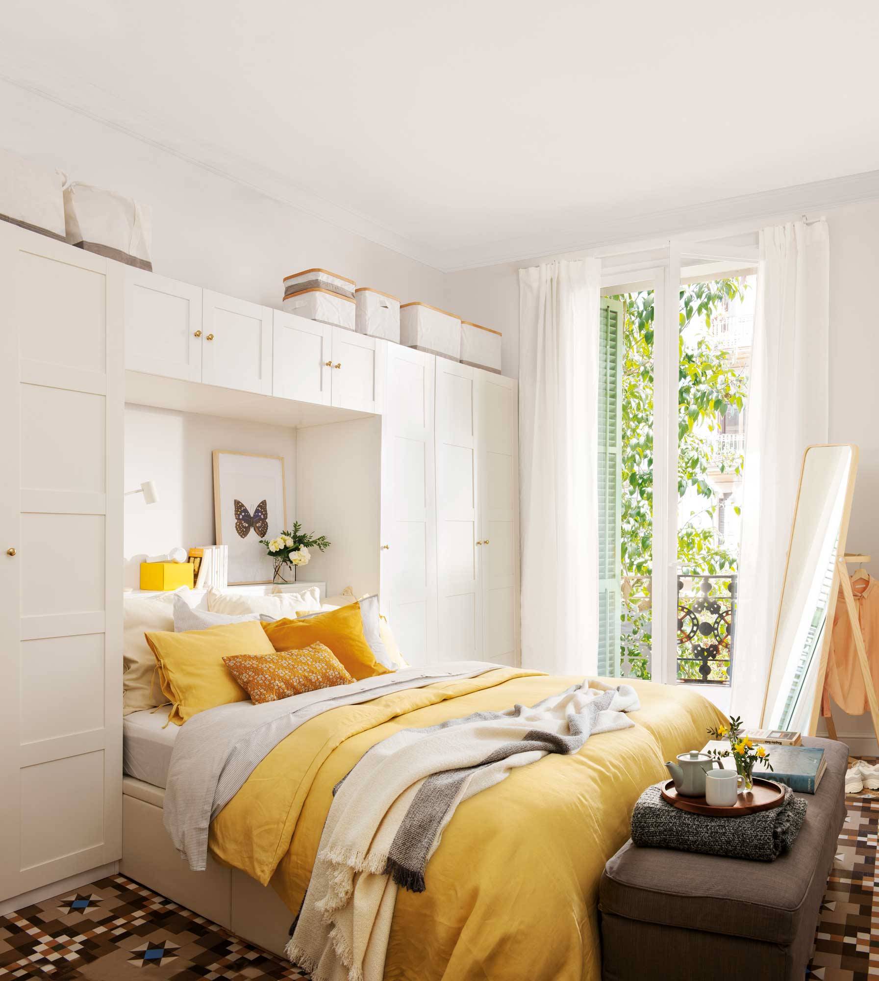 Dormitorio con estructura de armarios tipo puente y ropa de cama amarilla