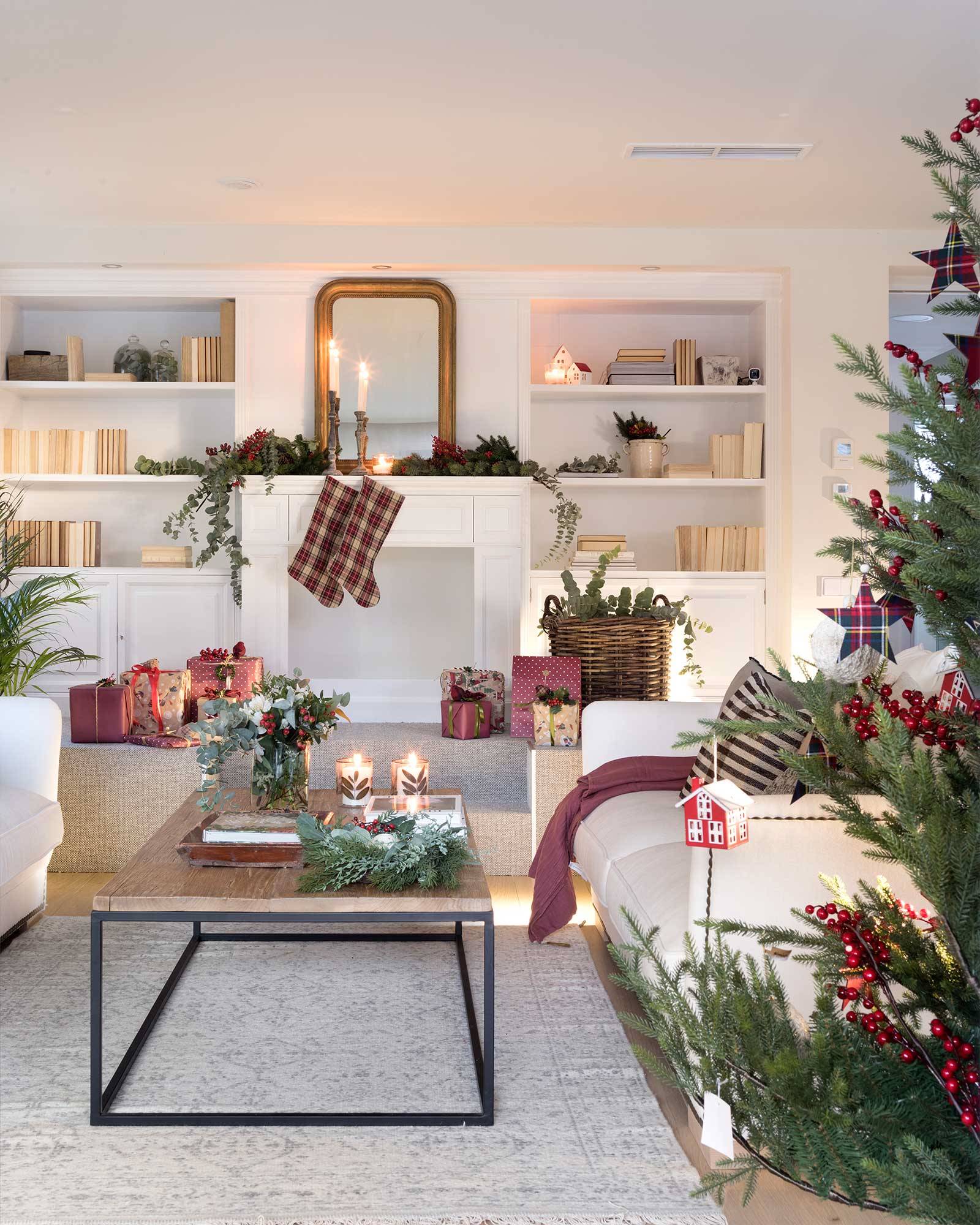 Salón blanco con chimenea decorado por Navidad. 