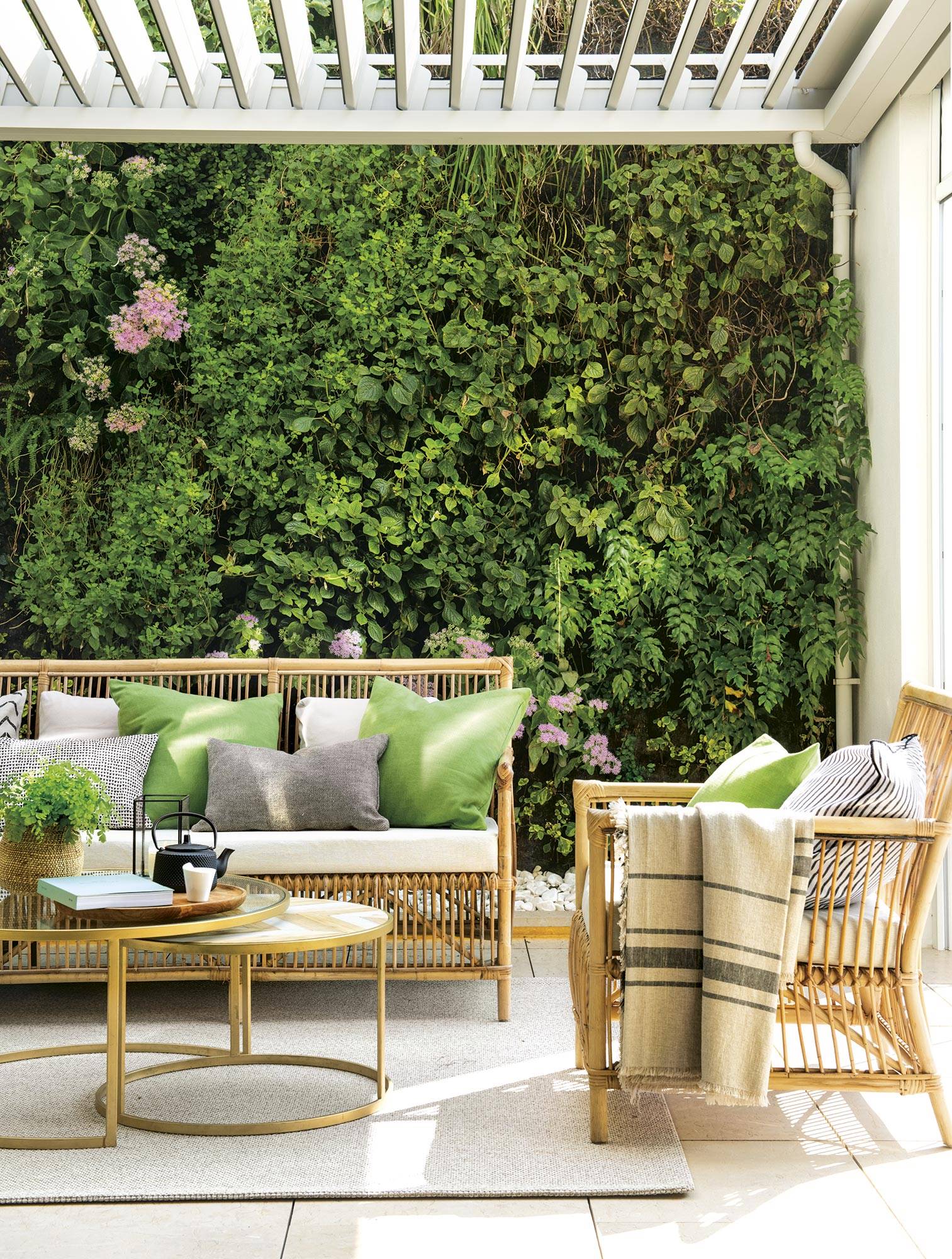 Terraza con muebles de fibras y pared con jardín vertical. 