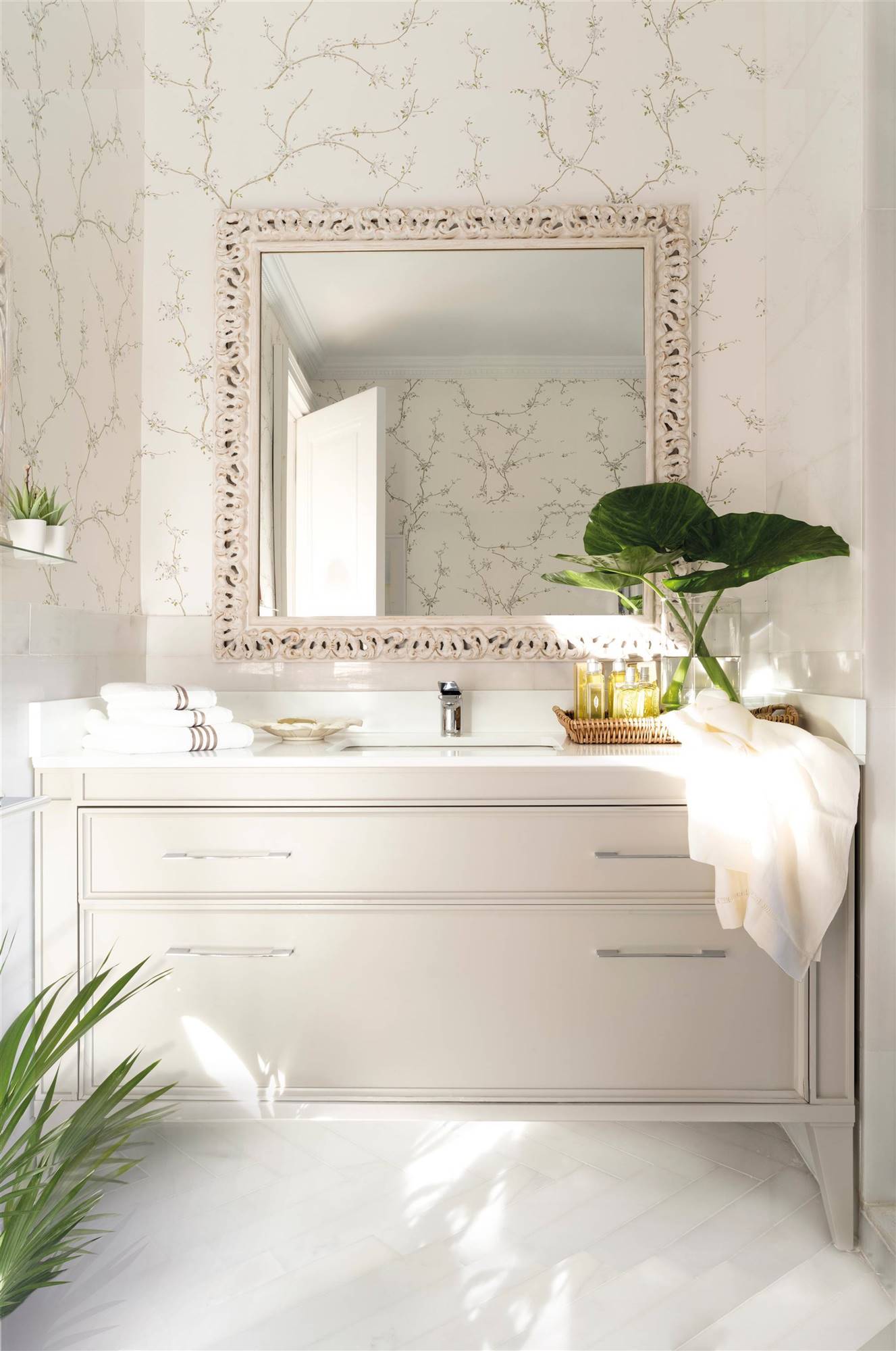 Baño blanco con papel pintado y espejo.
