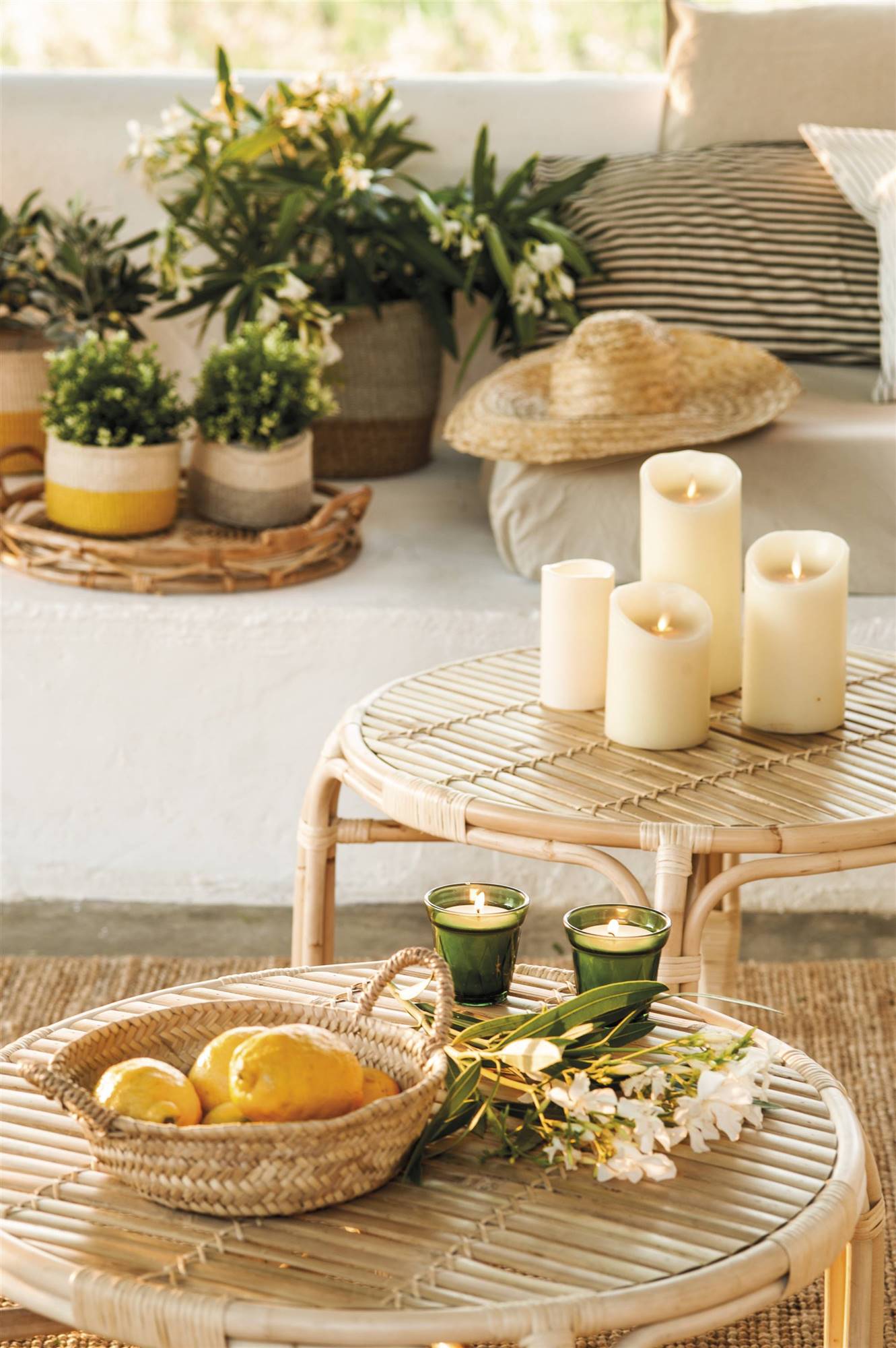 Terraza con mesa de centro de fibras con velas y cesta con limones.