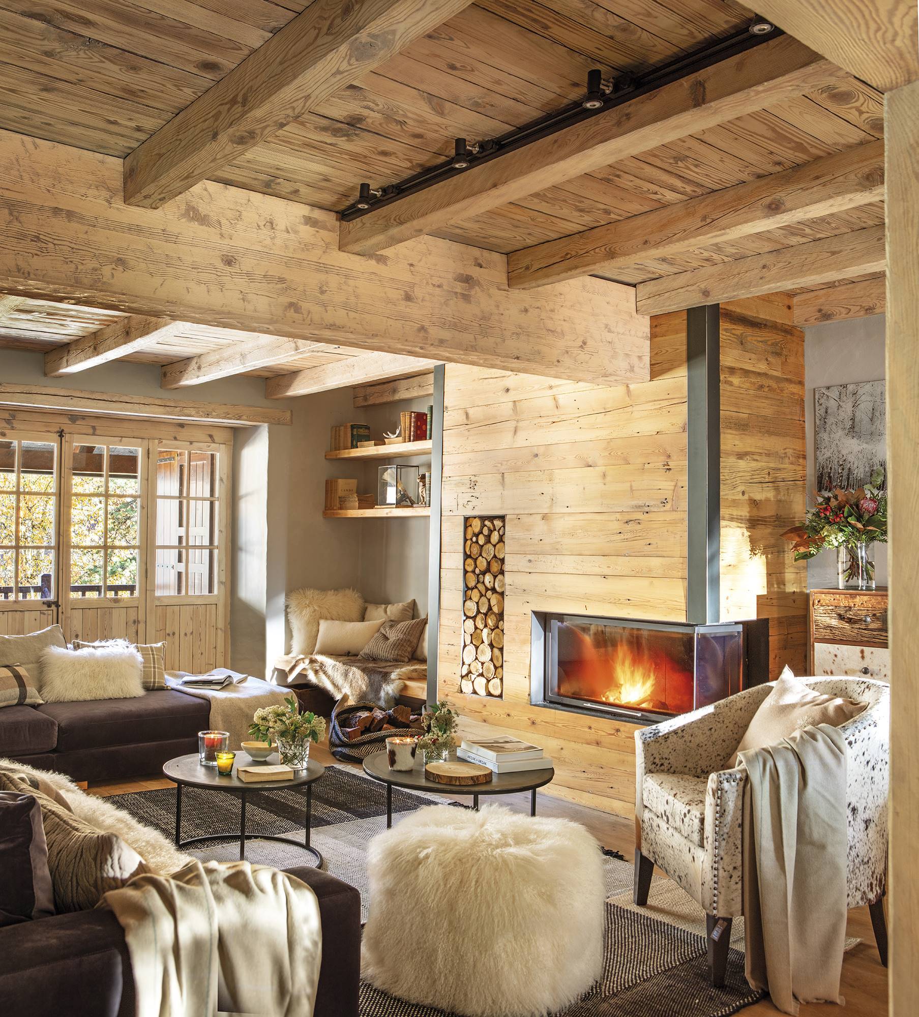 Salón de casa de montaña revestida de madera con chimenea 
