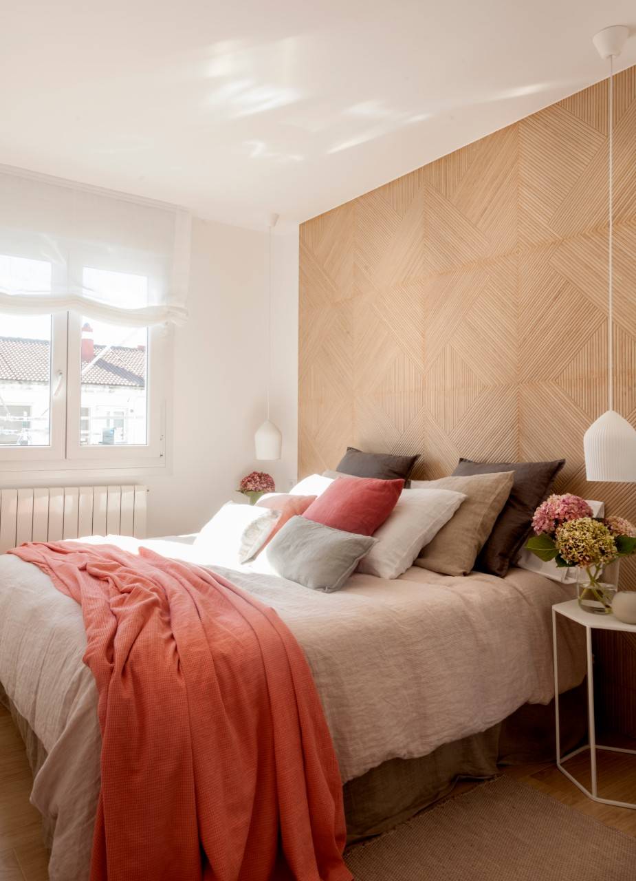 Dormitorio con pared revestida con cerámica que imita la madera. 