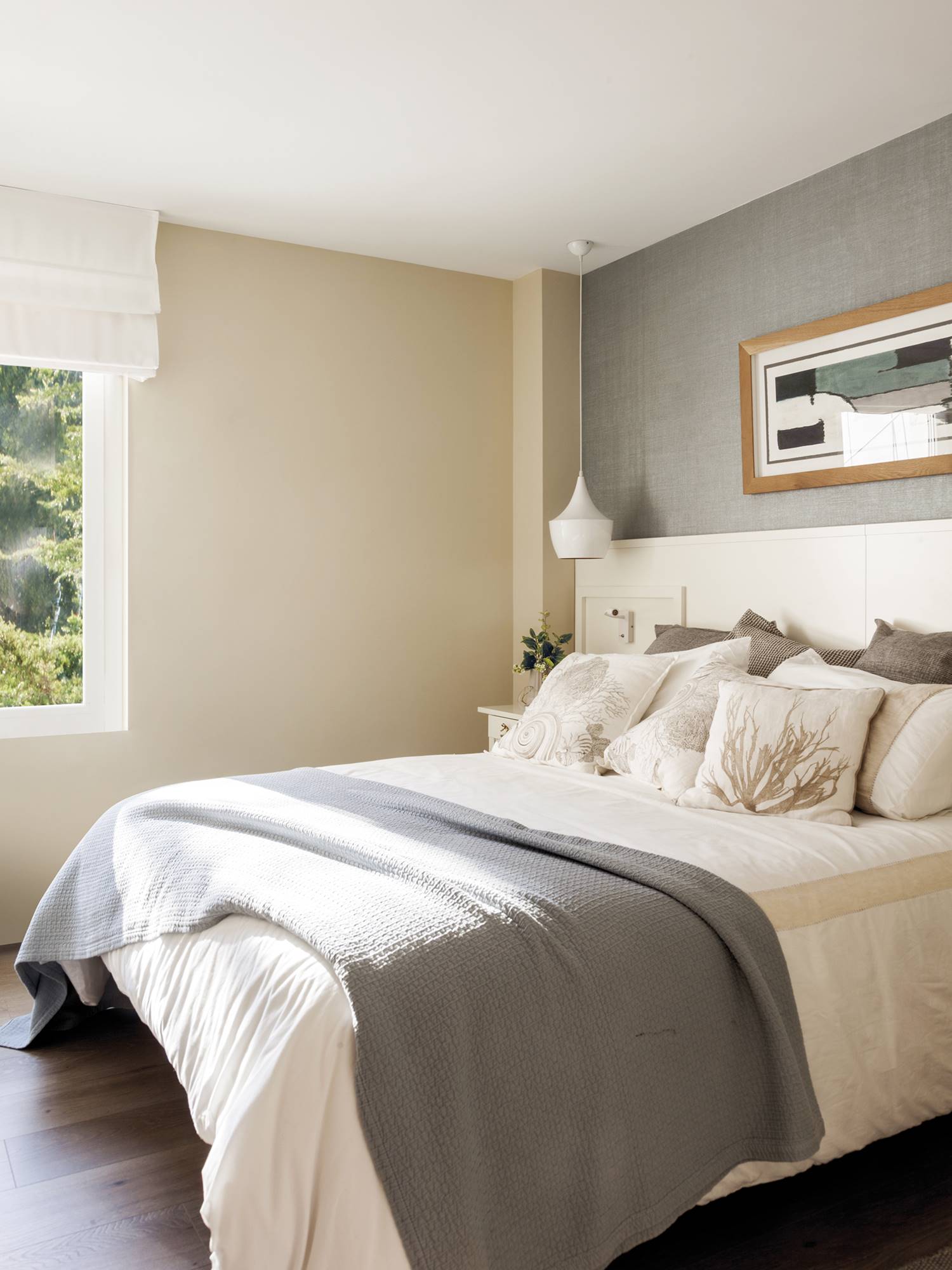Dormitorio con cabecero de madera blanco y papel pintado textil. 