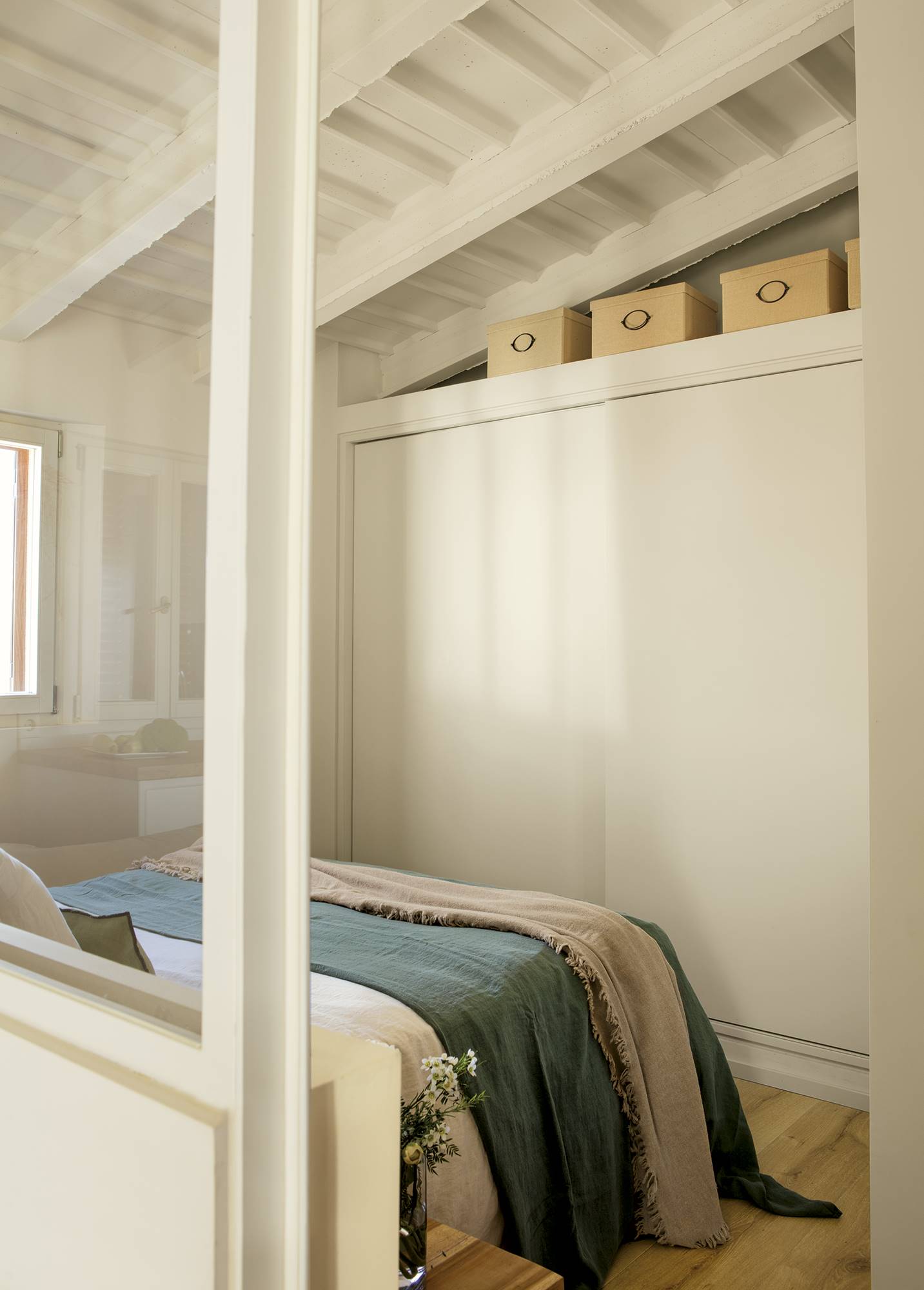 Dormitorio abuhardillado con armario con puertas correderas. 