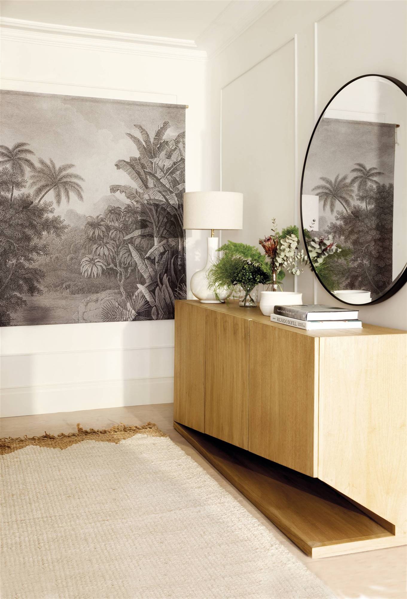 Recibidor moderno con mueble de madera y espejo redondo. 