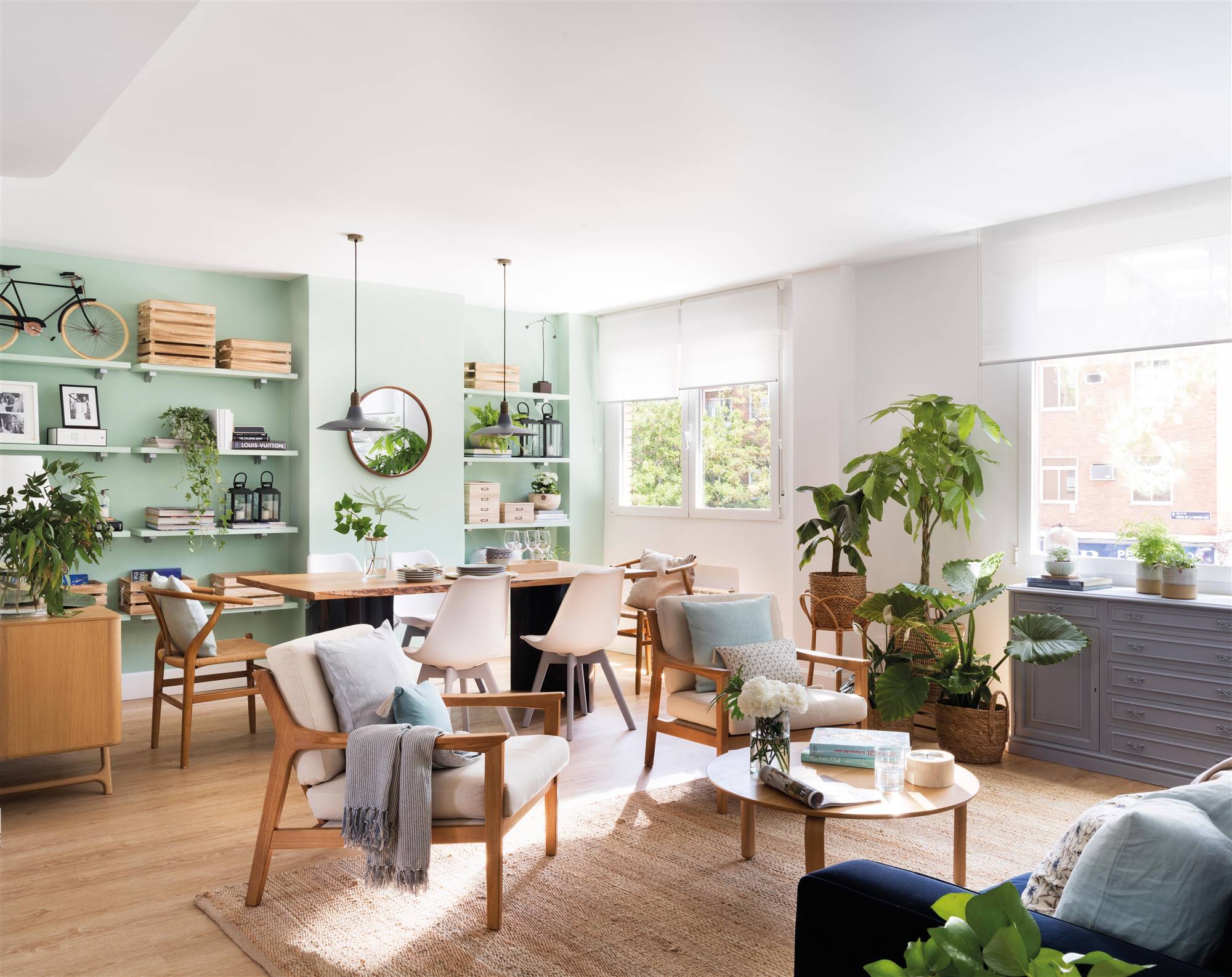 Salón comedor nórdico con pared de color verde pastel y muebles de madera 00510073