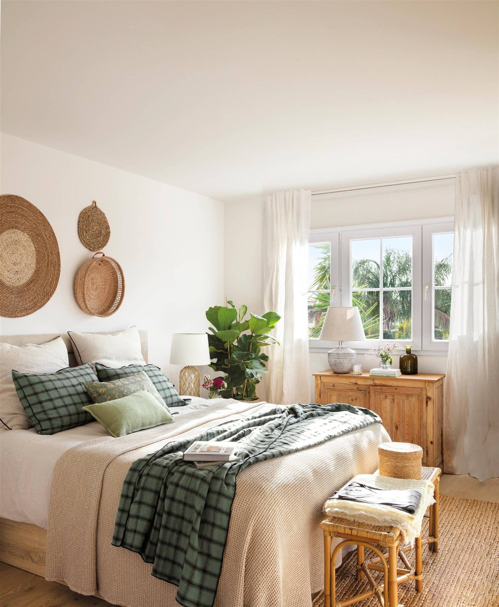 Dormitorio de estìlo boho chic con muebles en madera y adornos en fibra natural. 