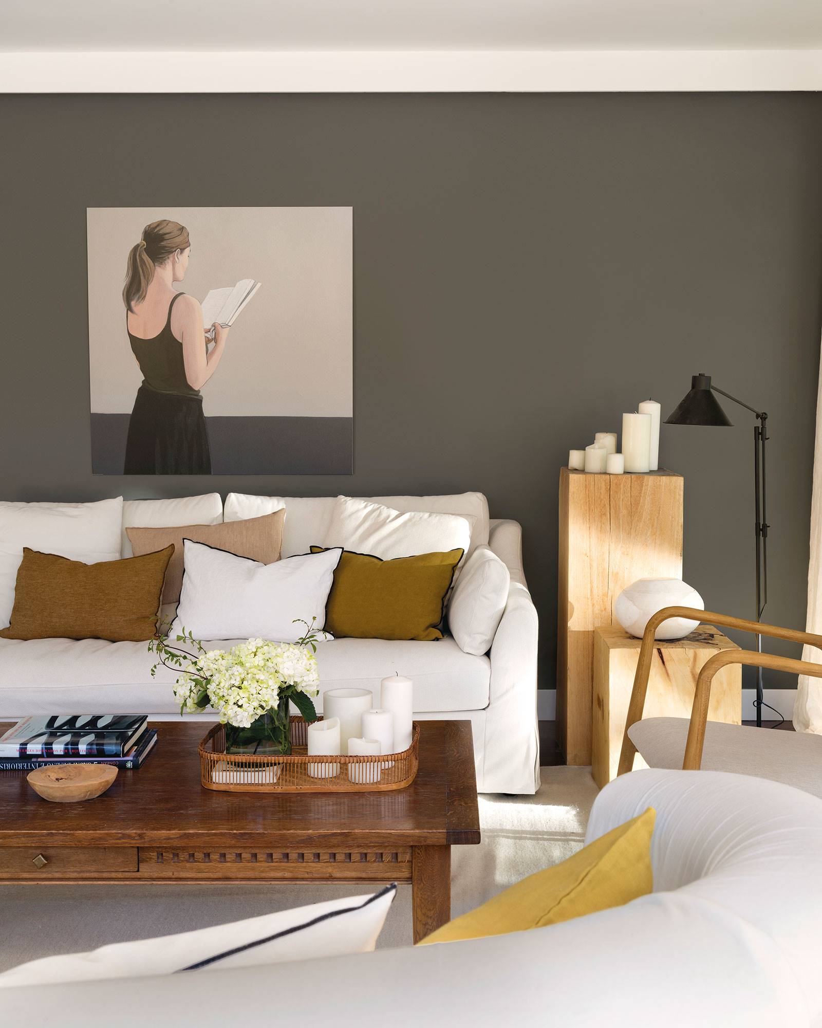 Salón con sofá blanco y pared gris oscuro con cuadro de mujer 00527472
