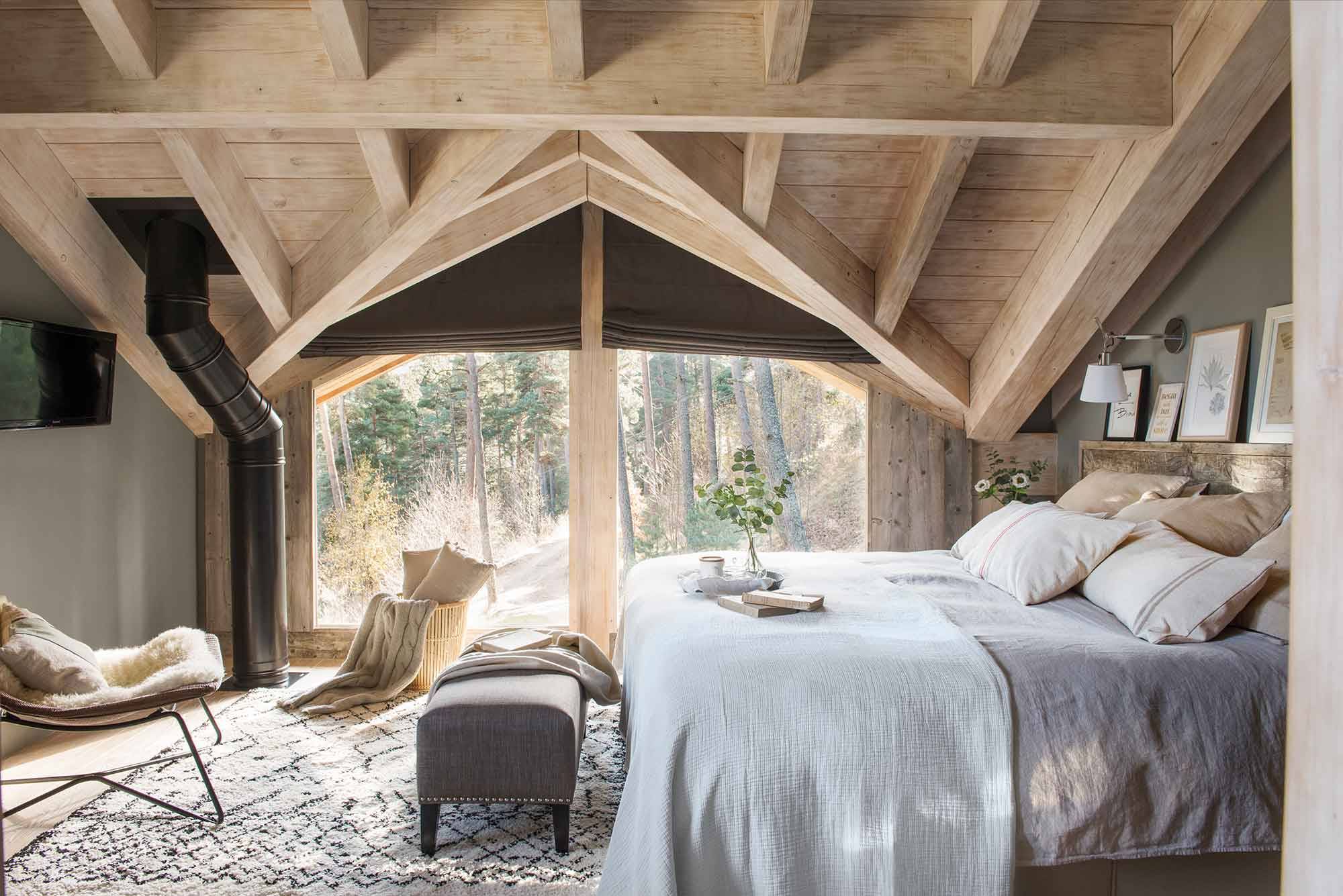 Casas en el bosque. Dormitorio rústico con techos abuhardillados de madera. 