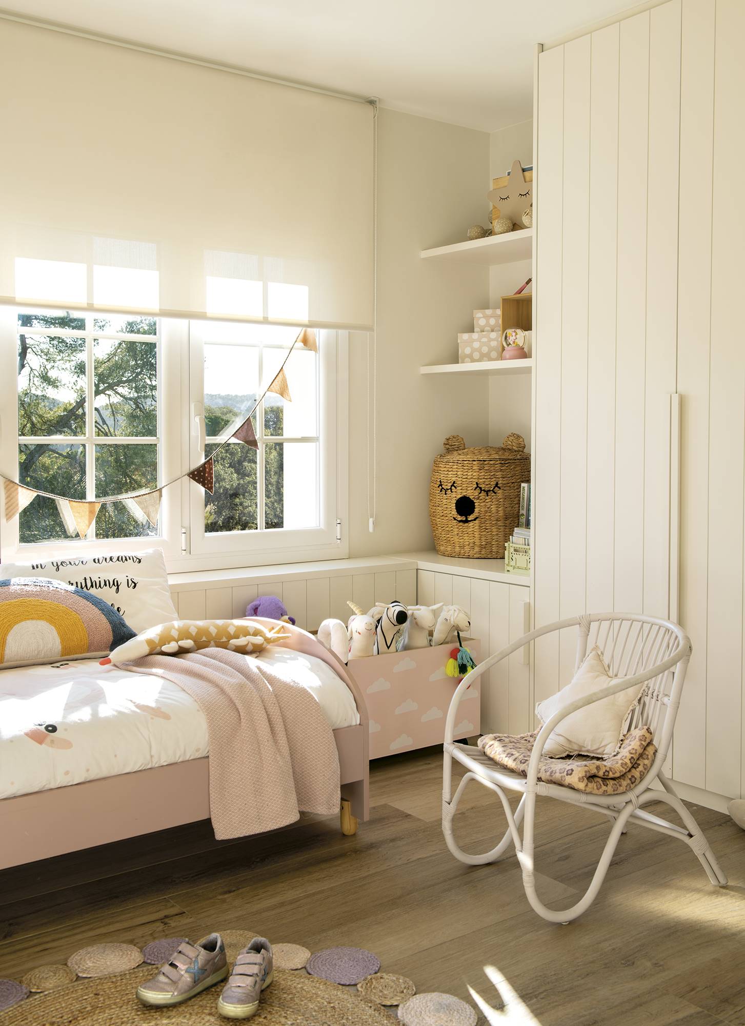 Habitación infantil con cama rosa y armario y estantería