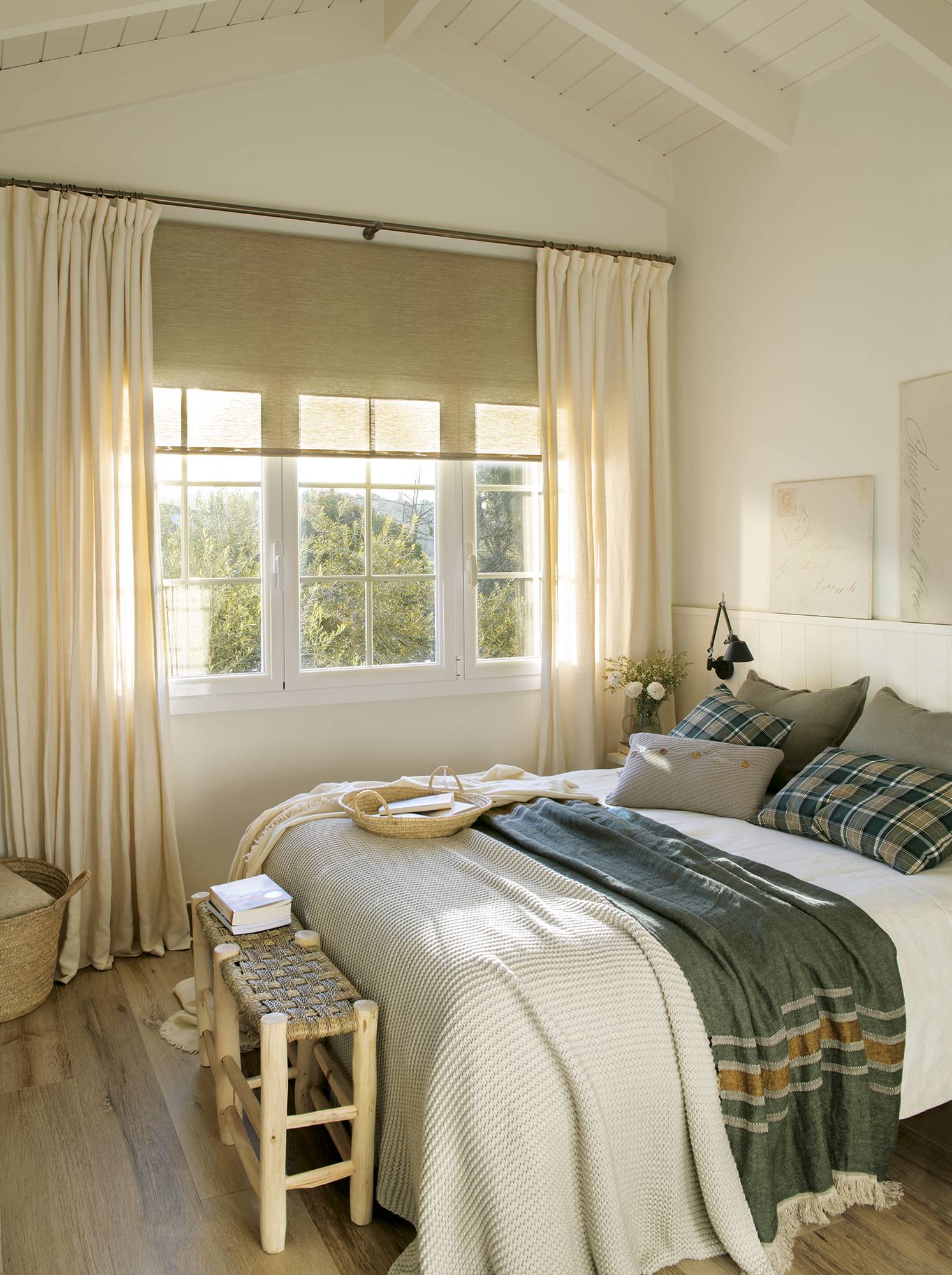 Dormitorio blanco con ventana con cuarterones y cabecero tipo murete