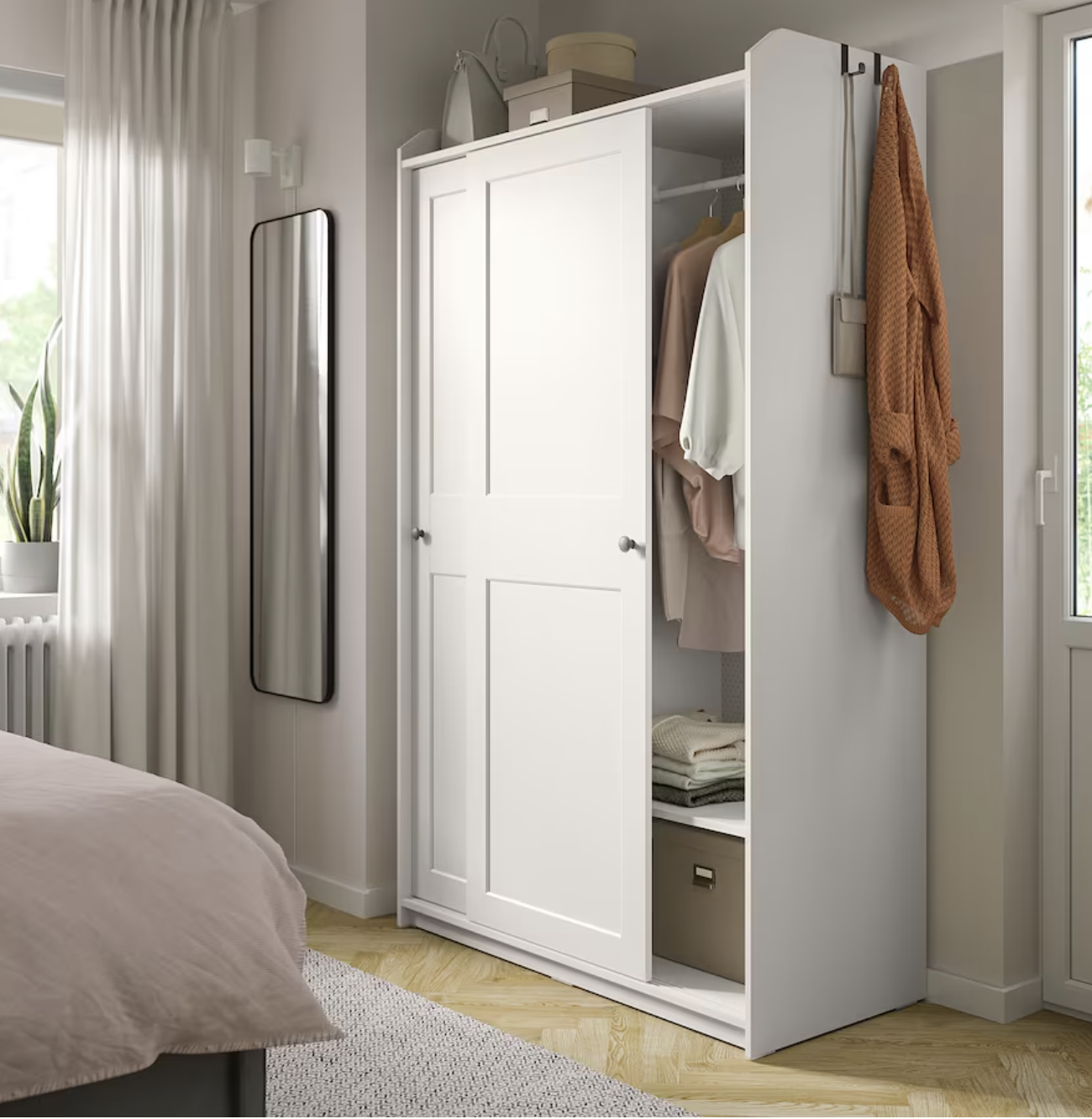 Ideas de IKEA para pisos pequeños 2022. Dormitorio pequeño con armario con puertas correderas HAUGA blanco.