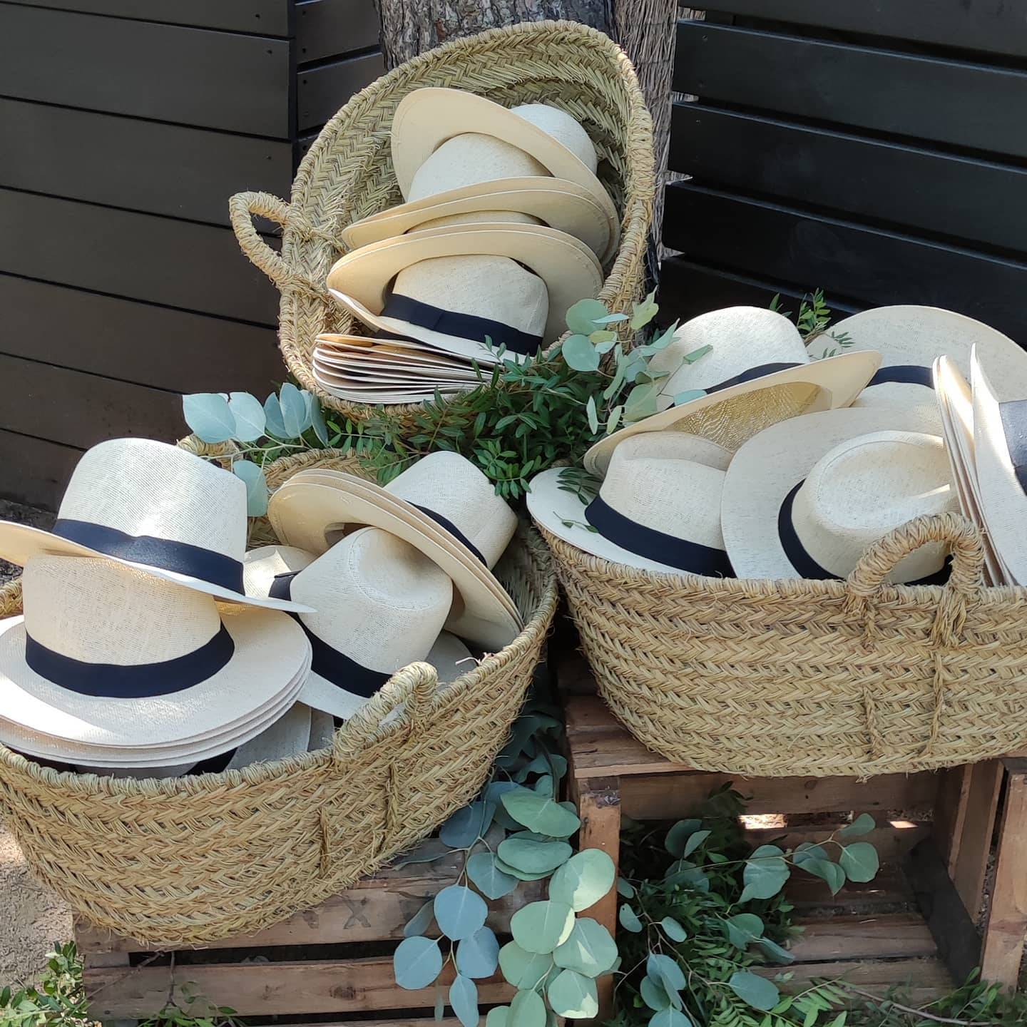 Decoracion de boda con cestas de mimbre para sombreros.