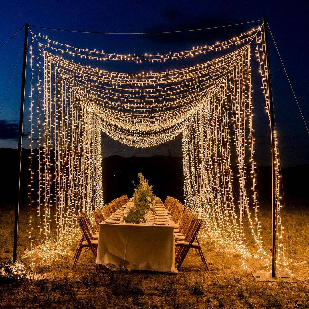 Ideas para boda al aire libre: una mesa para una boda en un campo de noche con luces.