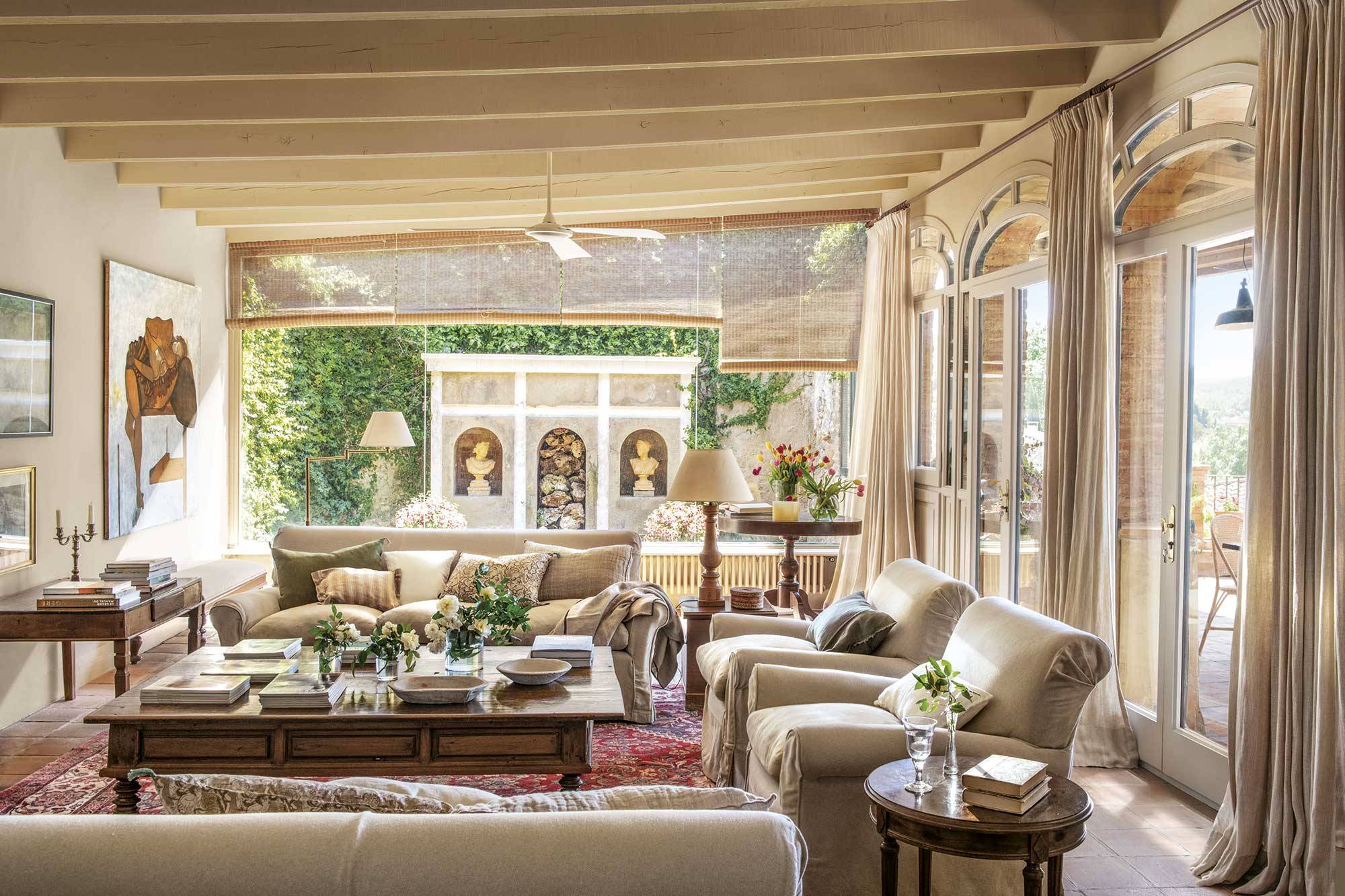 Salón de estilo clásico con sofás beige y muebles de maderas nobles. 