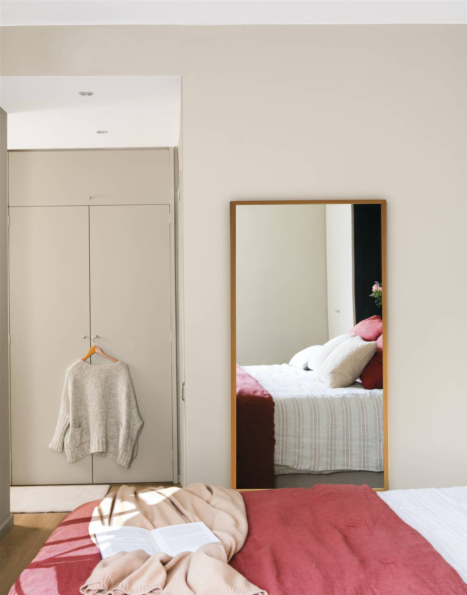 dormitorio moderno con espejo de pared y armarios con frentes lisos 00519633