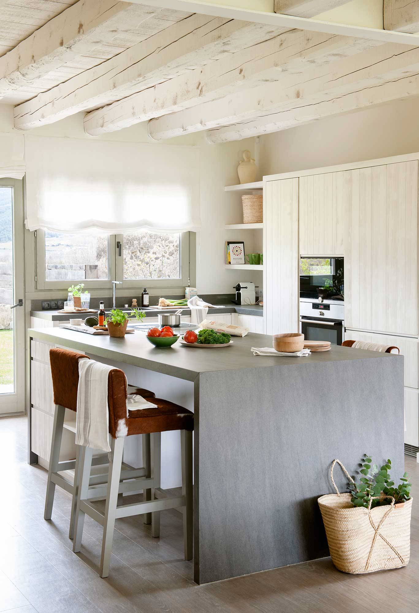 Cocina rústica moderna con muebles de madera blanca e isla de color gris. 