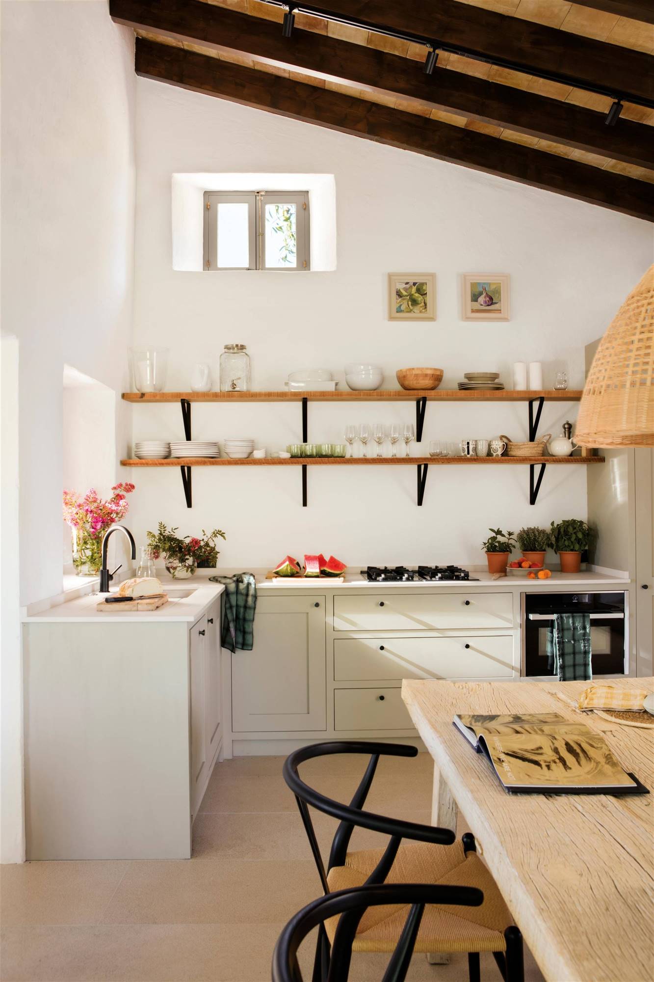 Cocina rústica moderna con muebles bajos blancos y estantes de madera.