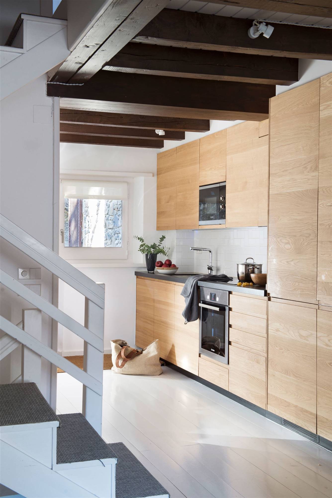 Cocina de estilo rústico moderno con muebles de madera panelados y suelo blanco. 